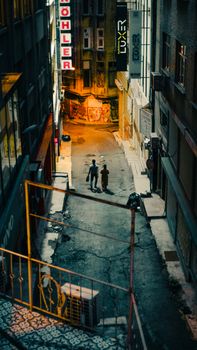 Two people walking in a dimly lit urban alley at night, creating a moody atmosphere.