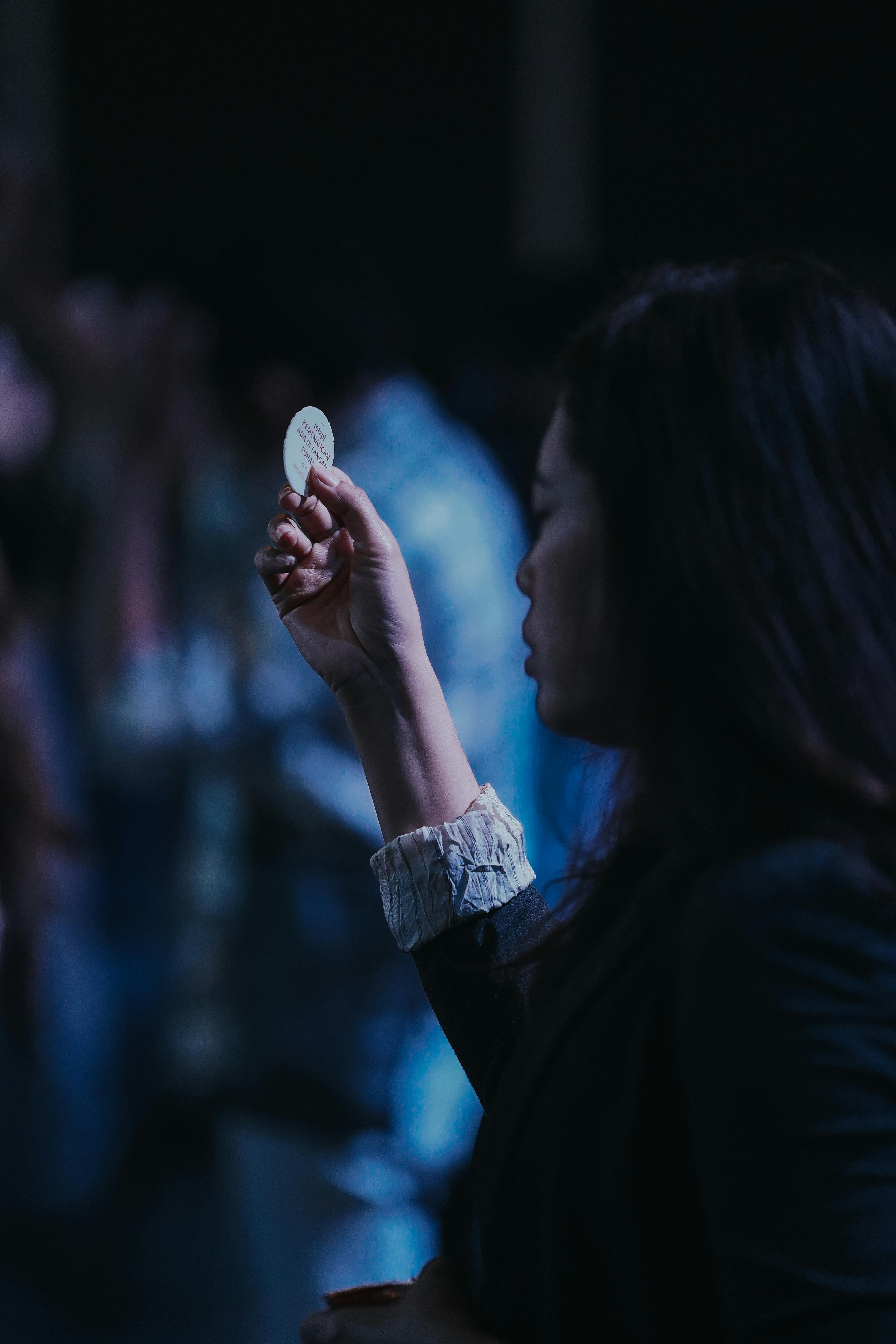 Miễn phí Hình ảnh nhìn nghiêng của một người phụ nữ cầm bánh thánh trong buổi lễ nhà thờ, tượng trưng cho đức tin tôn giáo. Ảnh lưu trữ