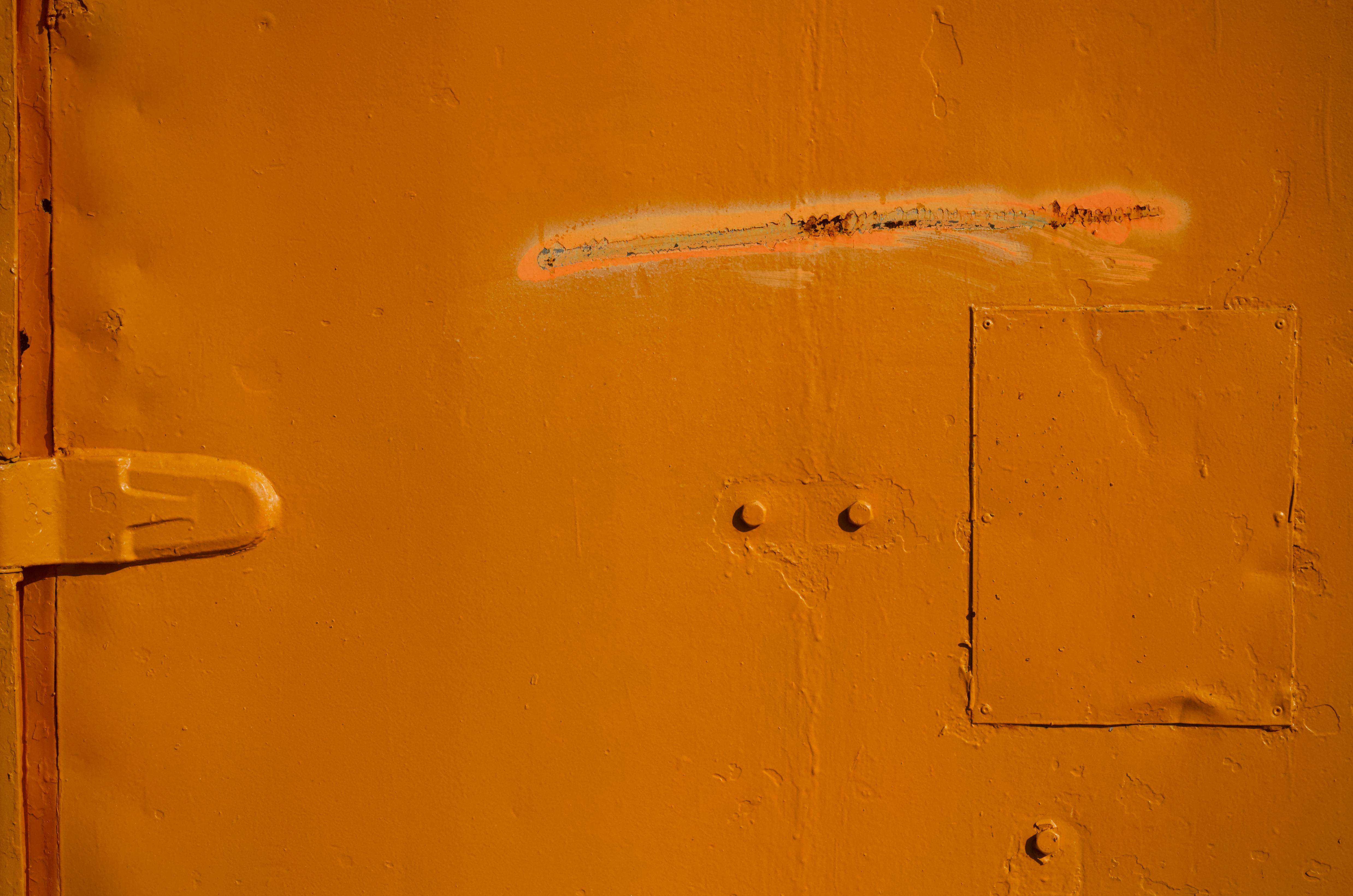 bezplatná Detailní pohled na texturovaný rezavý oranžový kovový povrch se šrouby a dveřním pantem. Základová fotografie
