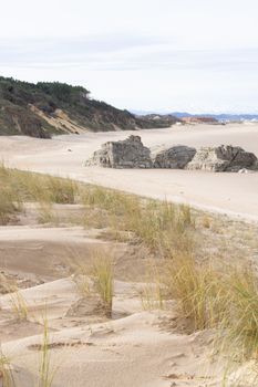 Serene sandy beach in Somo, Cantabria with natural dunes and rocky formations.