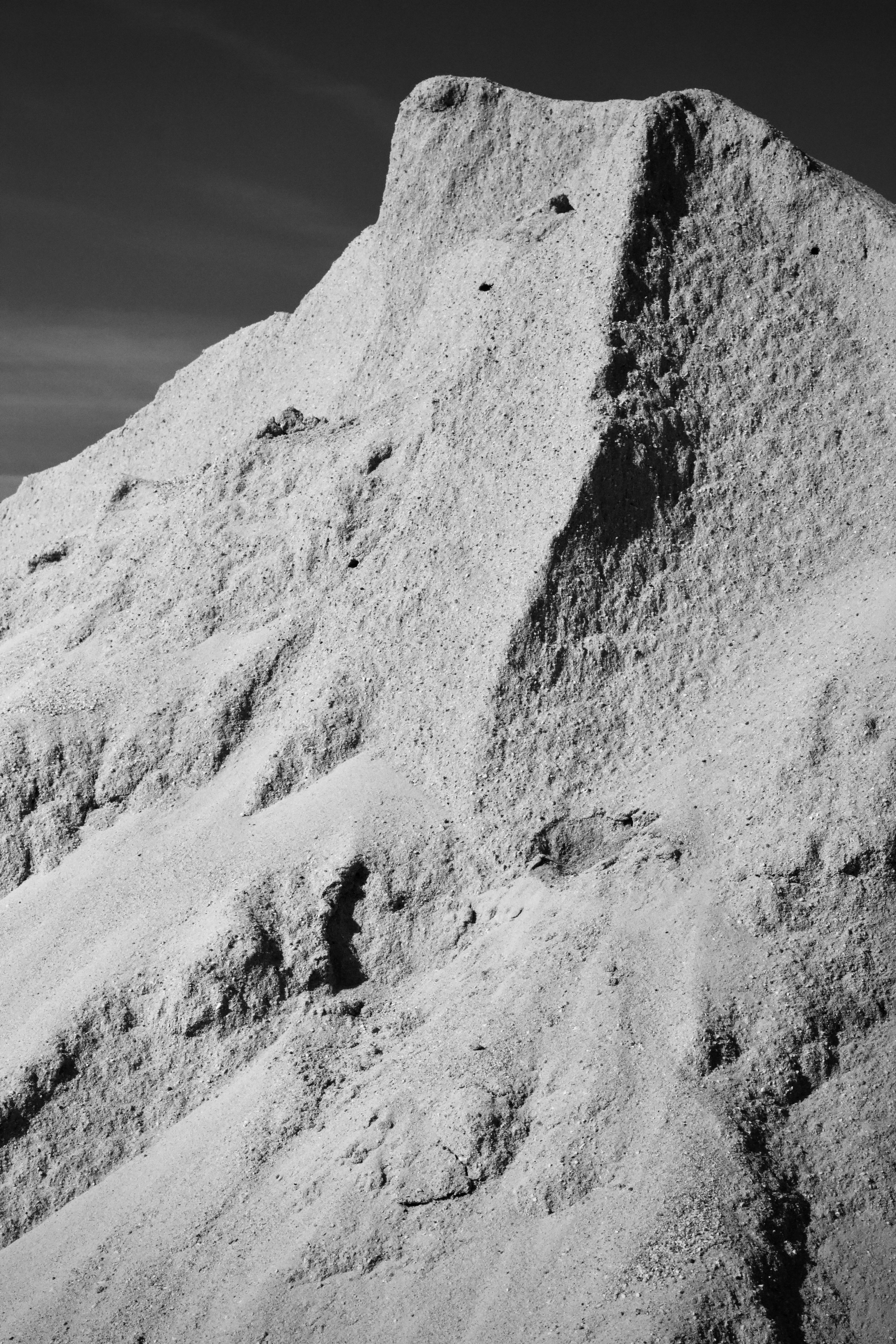 Gratis Monokromt bilde av en kupert, fjellrik fjellformasjon under en klar himmel. Arkivbilde