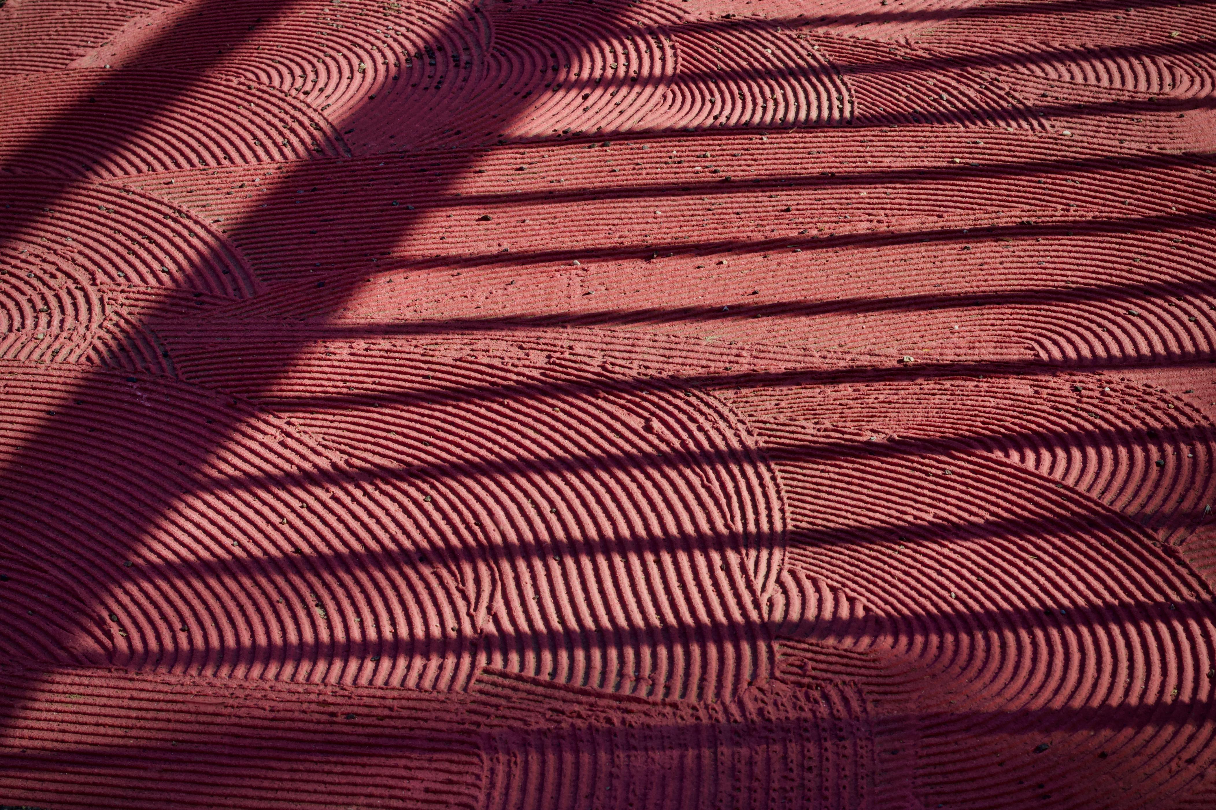 Gratis Patrón abstracto de arena rastrillada con sombras en un jardín zen, creando una escena tranquila y artística. Foto de stock
