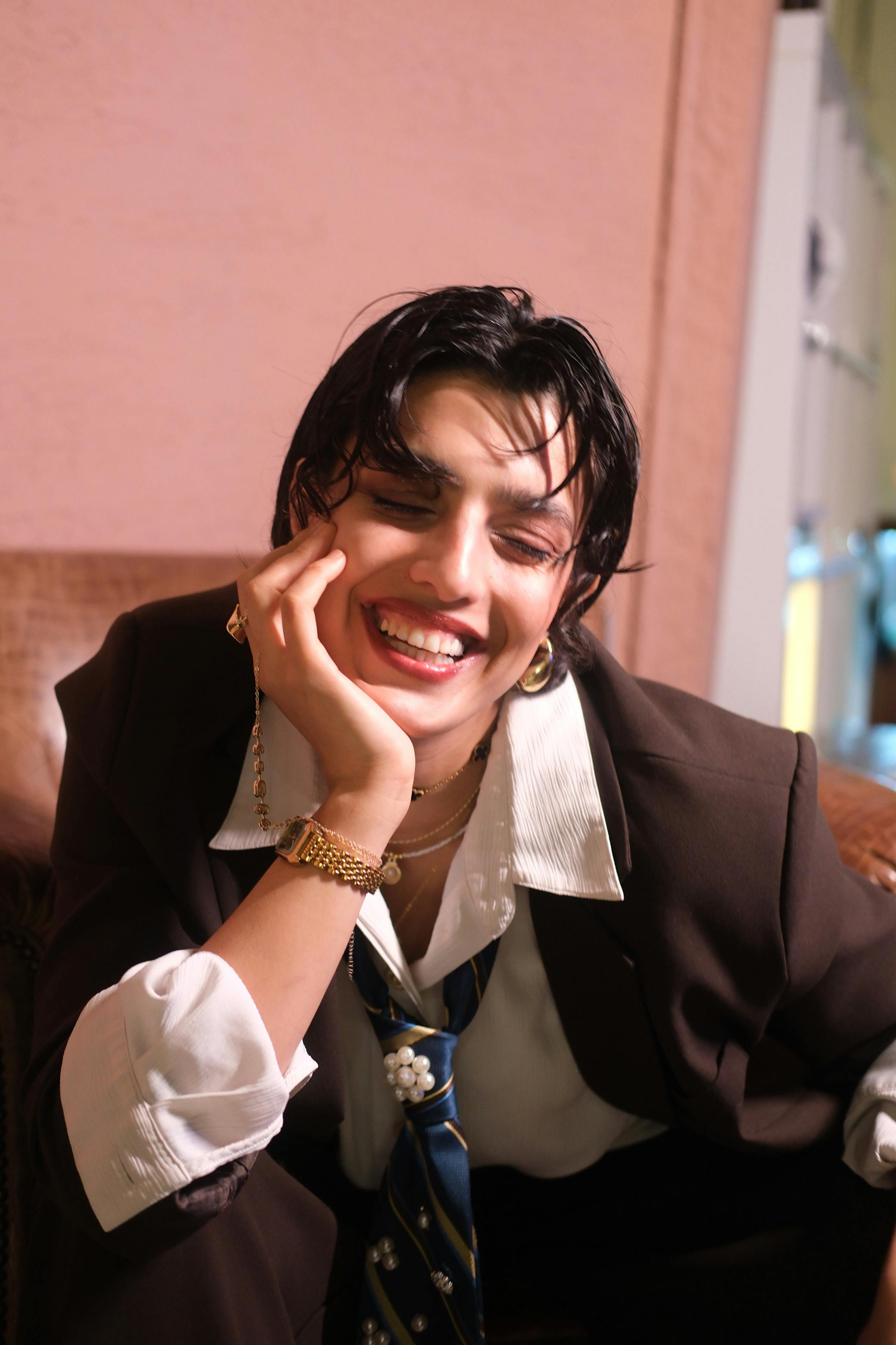 ฟรี ผู้ใหญ่หน้าตาแจ่มใส นั่งอยู่ในอาคาร สวมชุดสูท และยิ้มอย่างอบอุ่น คลังภาพถ่าย