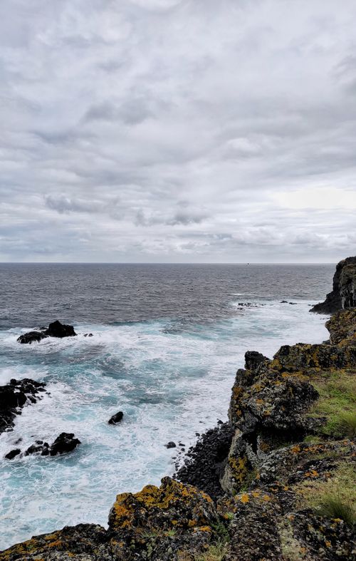 Free Captivating seascape featuring rugged cliffs and a dramatic cloudy sky in the Açores, Portugal. Stock Photo