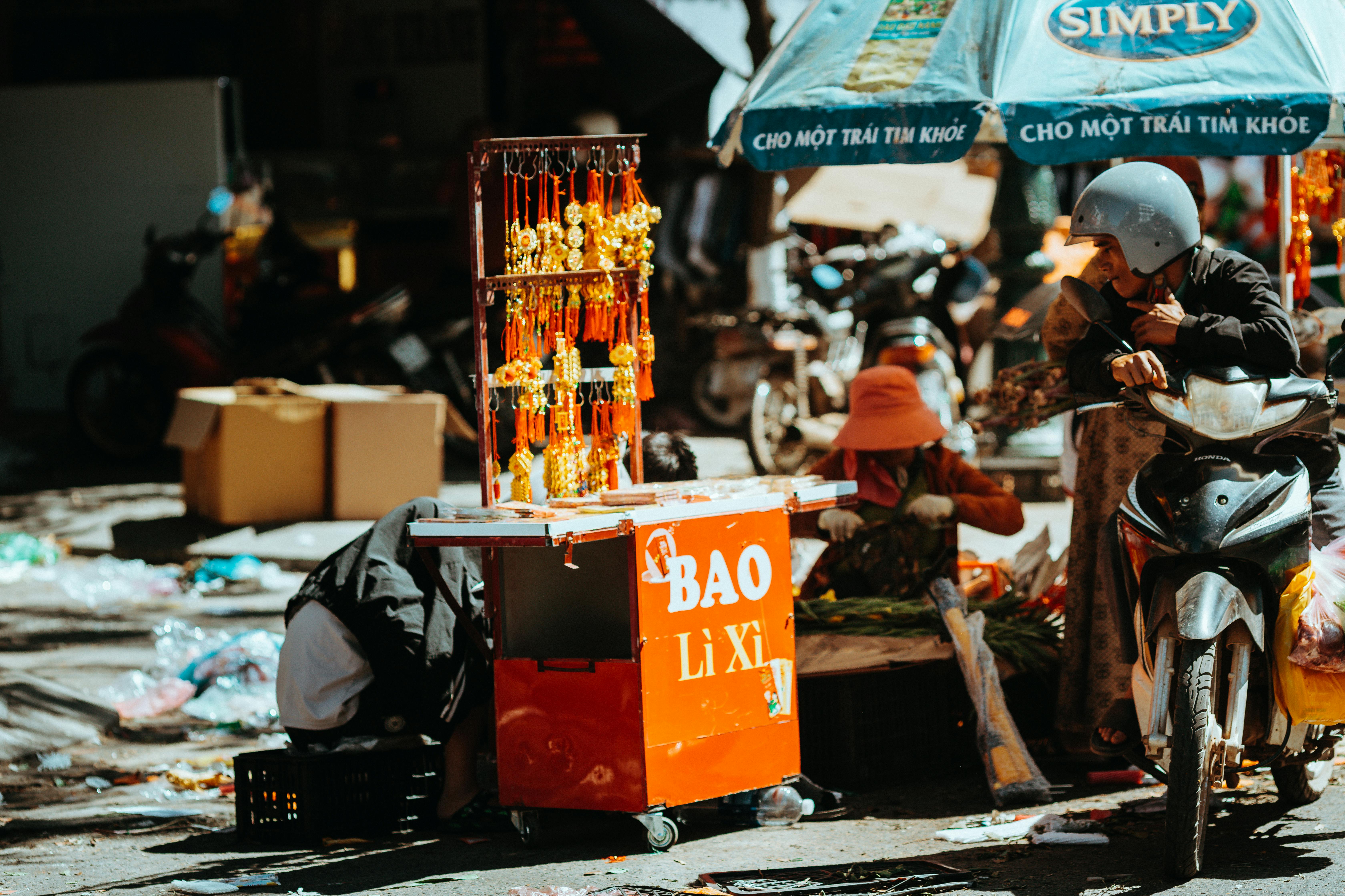 bezplatná Rušný pouliční trh se skútry a živými stánky v městském prostředí. Základová fotografie