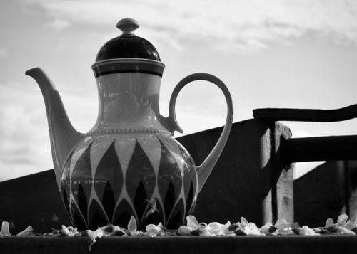 Free Artistic black and white photo of a decorative ceramic teapot displayed outdoors. Stock Photo