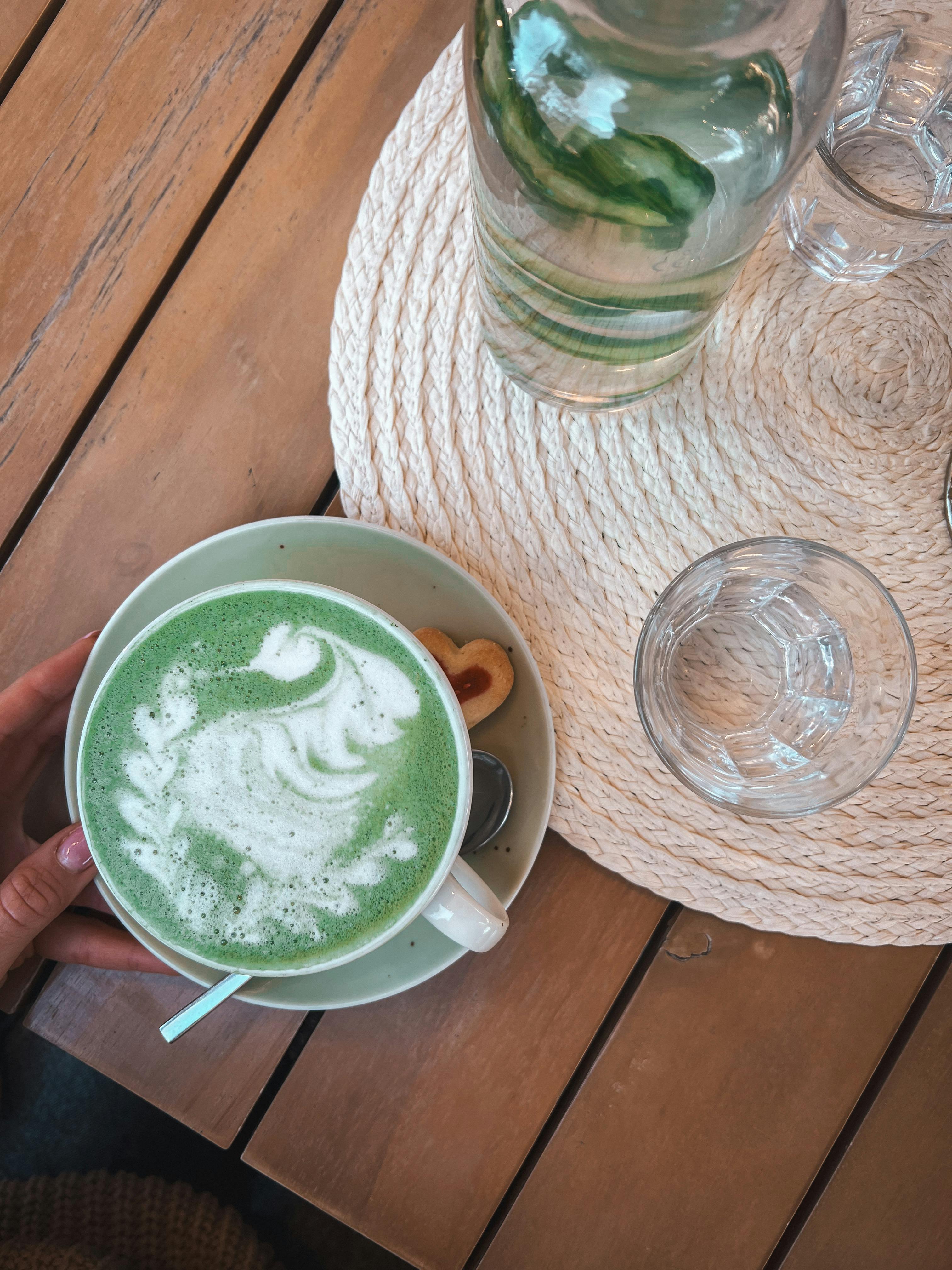 ฟรี เพลิดเพลินไปกับมัทฉะลาเต้สีสันสดใส ตกแต่งด้วยฟองนมสวยงามประณีต เหมาะสำหรับคนรักคาเฟ่ คลังภาพถ่าย