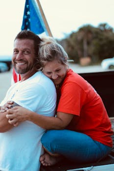 一对幸福的夫妇在美国国旗背景下拥抱，洋溢着欢乐