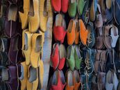 Vibrant display of traditional Moroccan leather slippers in various colors in a market.