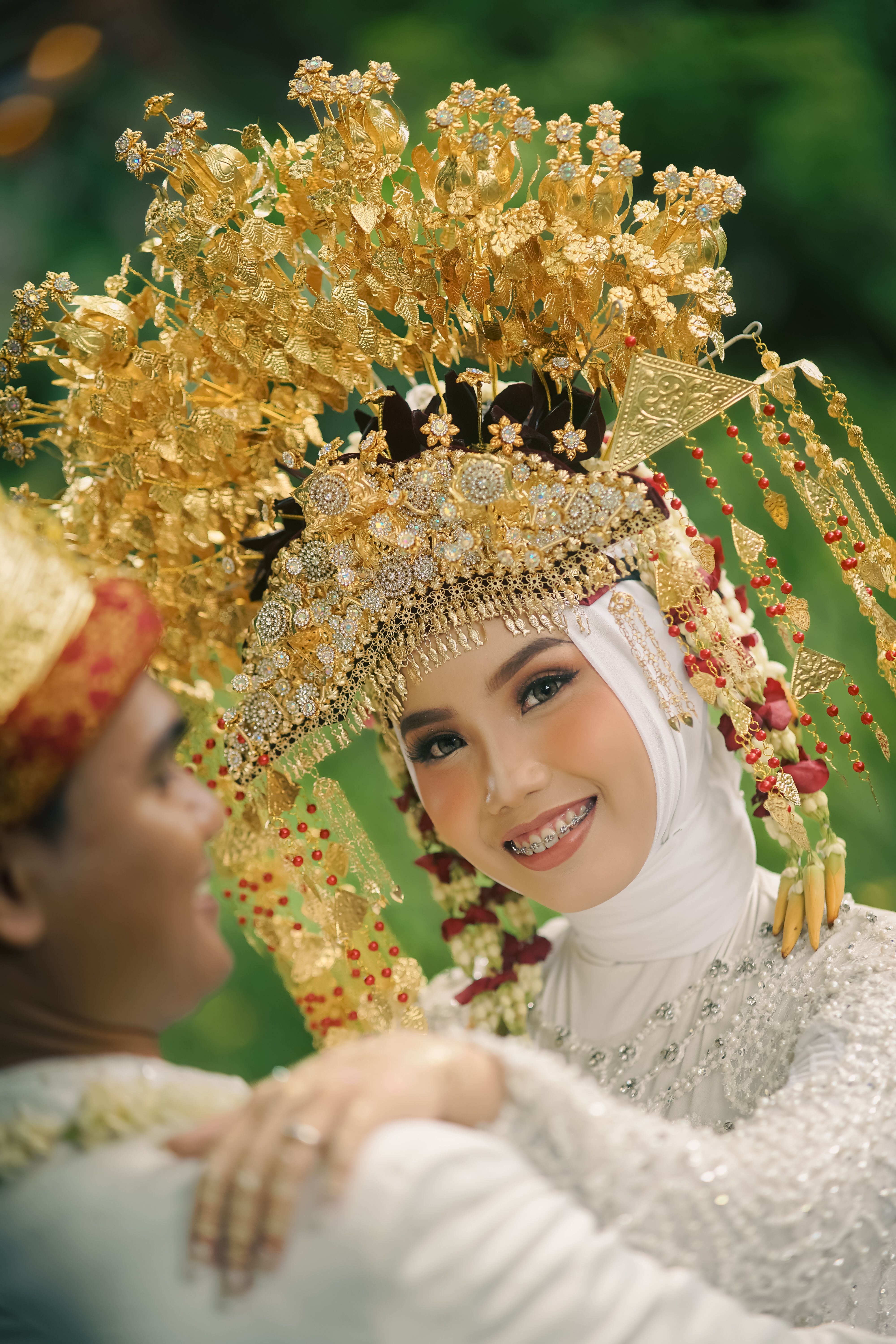 Bride in ornate traditional Indonesian wedding attire with golden headpiece in Jakarta.
