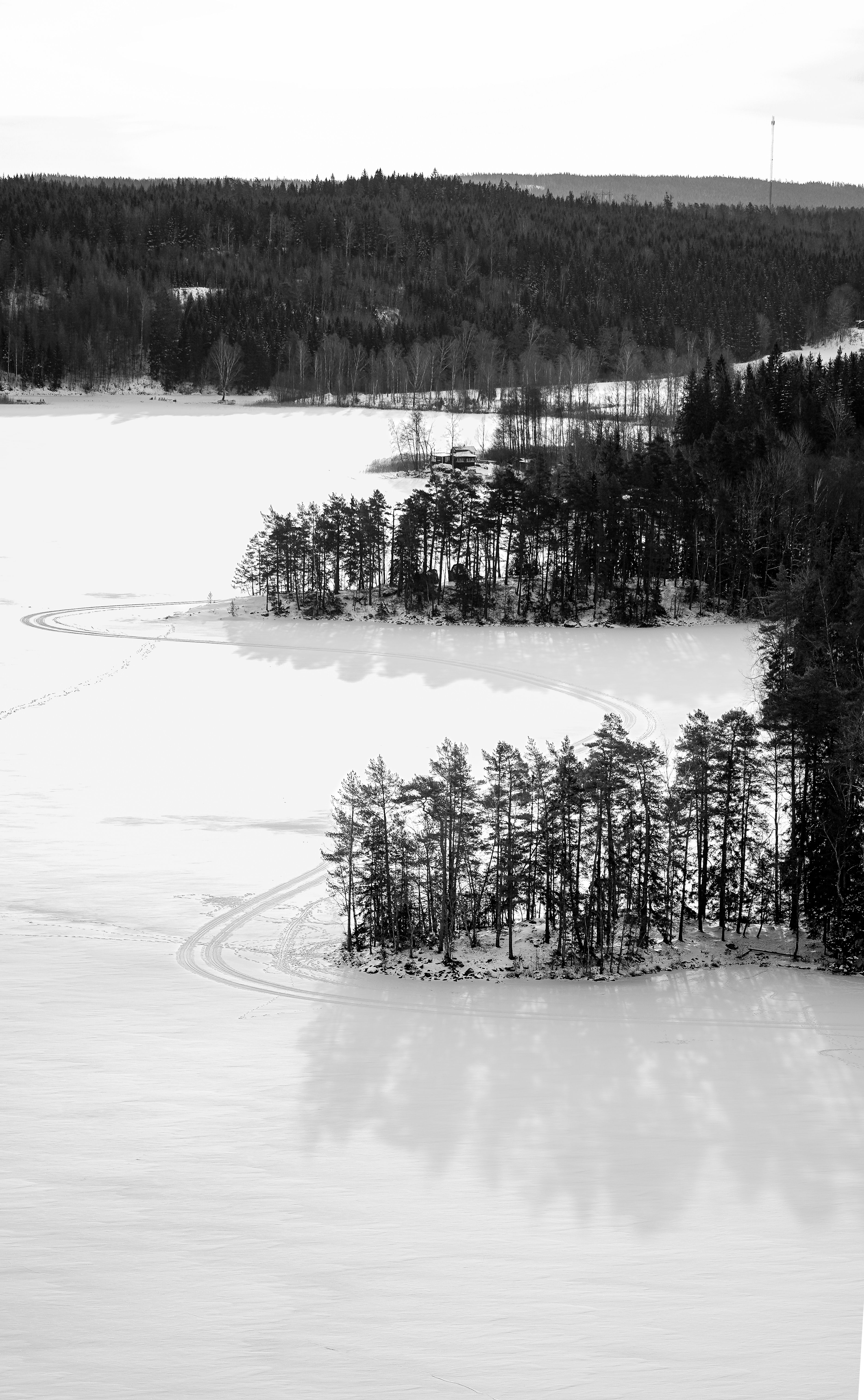 A serene aerial view of a snowy Swedish landscape during winter.