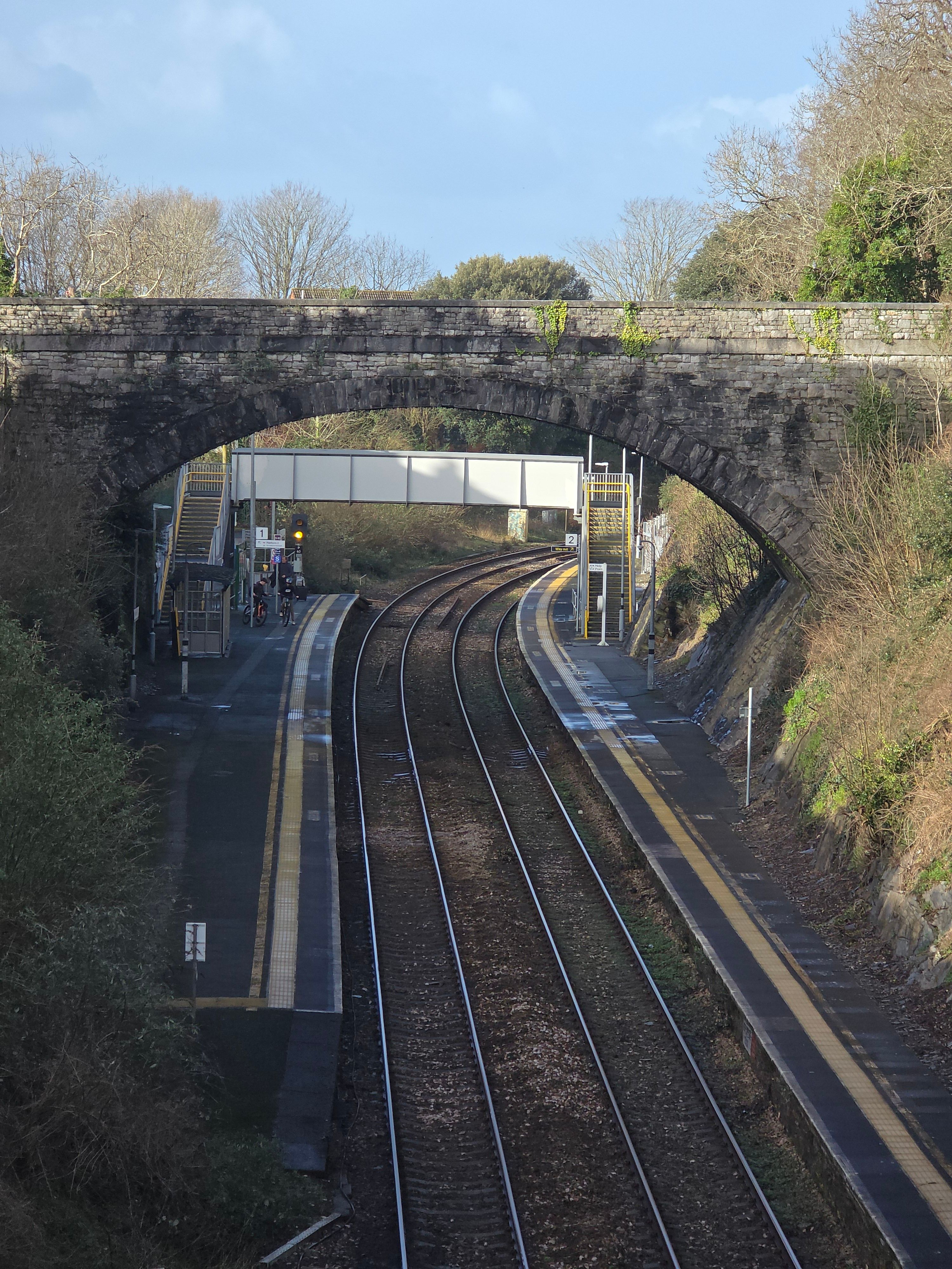 Scenic Railway Tracks Under Stone Bridge · Free Stock Photo