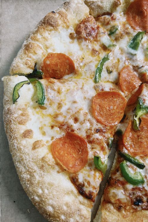 Free Delicious pepperoni pizza with melted cheese and green peppers, perfect for a savory treat. Stock Photo