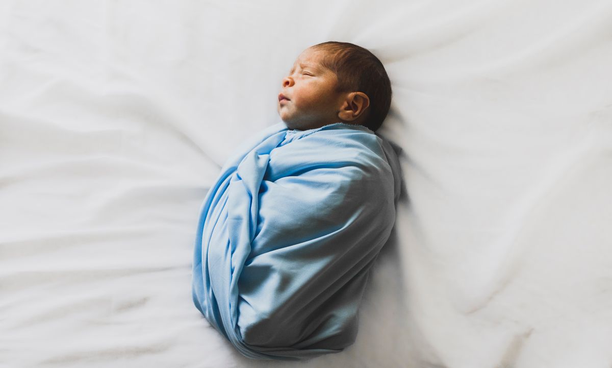 Baby sleeping in a transitional arms-out sleep sack