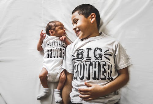 Фотография новорожденного рядом с мальчиком