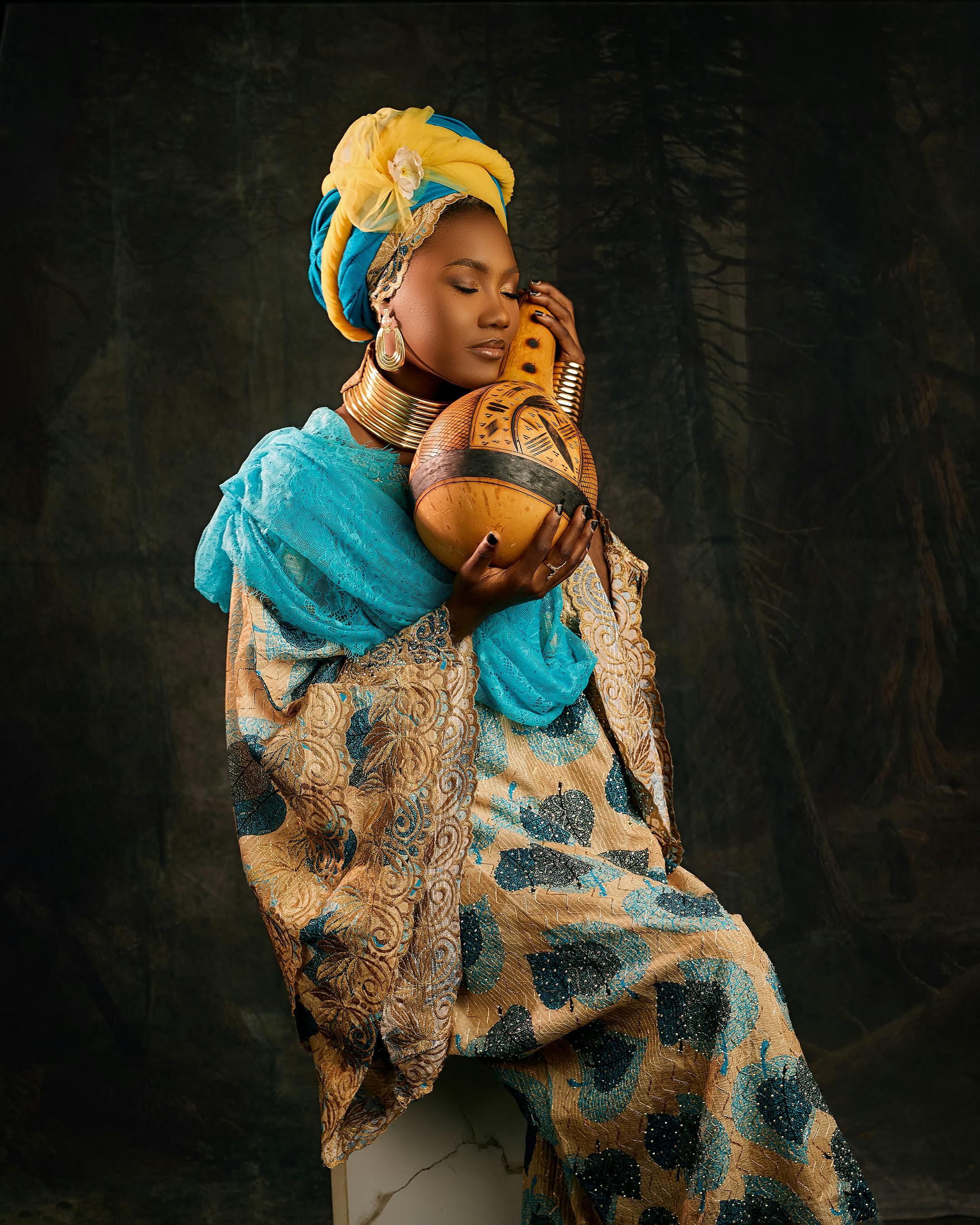 Ilmainen Afrikkalainen nainen perinteisessä asussa, värikkäässä päähineessä, calabash kädessään. Kuvapankkikuva