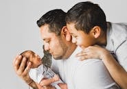 父亲和儿子们与新生儿共享了快乐的家庭时光