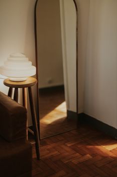 Warm interior view with a stylish lamp and wooden floor.