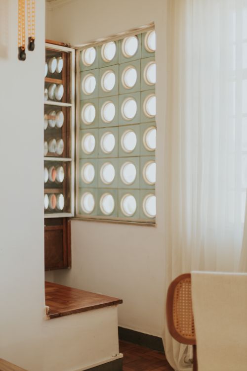 Free Calm, earthy-toned interior with unique circular glass window design, exuding a minimalist and cozy atmosphere. Stock Photo