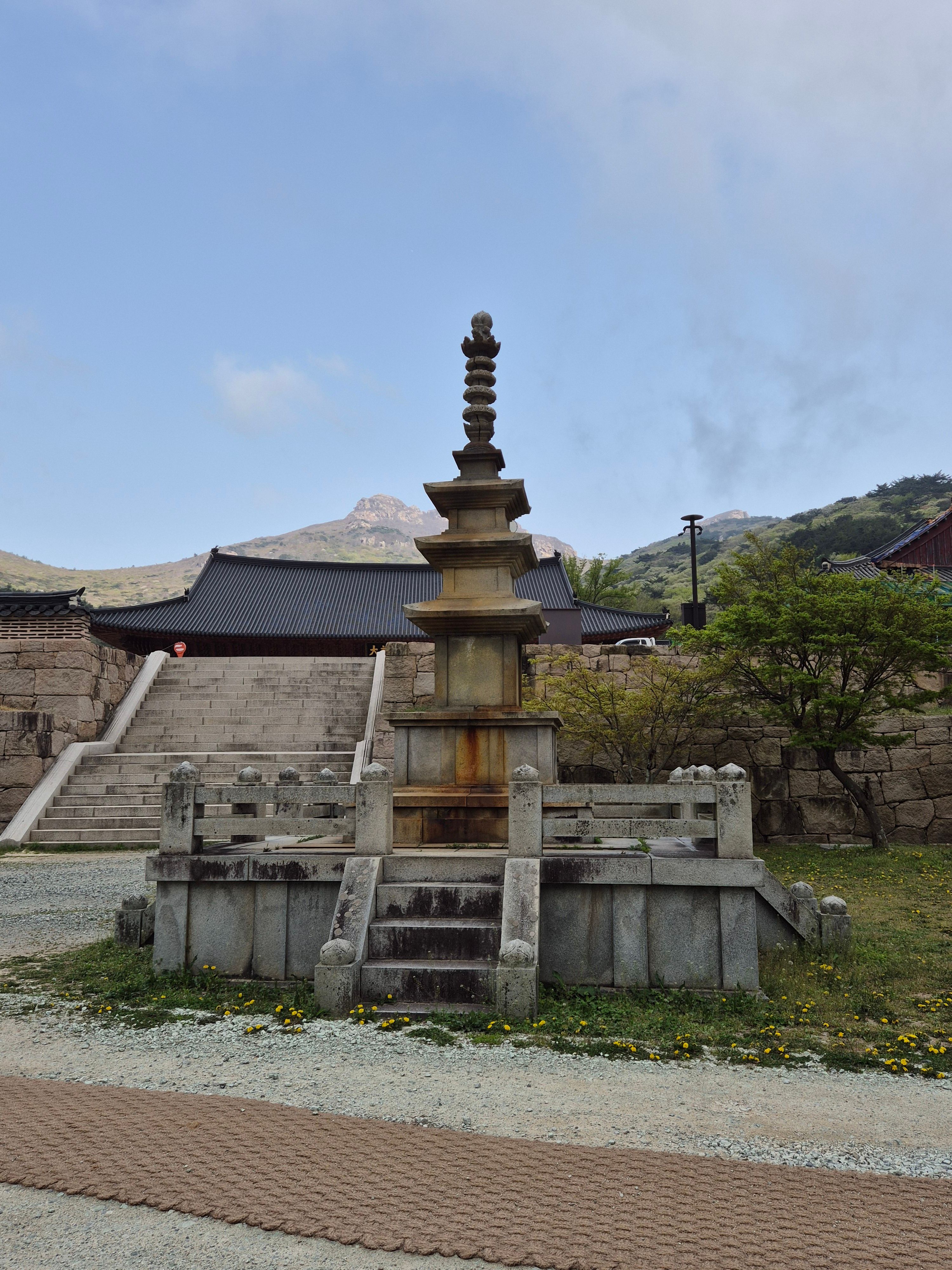 A tranquil scene of a historic Korean pagoda with a mountain backdrop, perfect for cultural exploration themes.