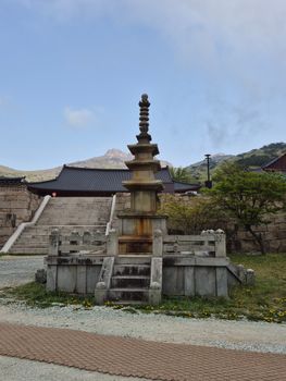 A tranquil scene of a historic Korean pagoda with a mountain backdrop, perfect for cultural exploration themes.