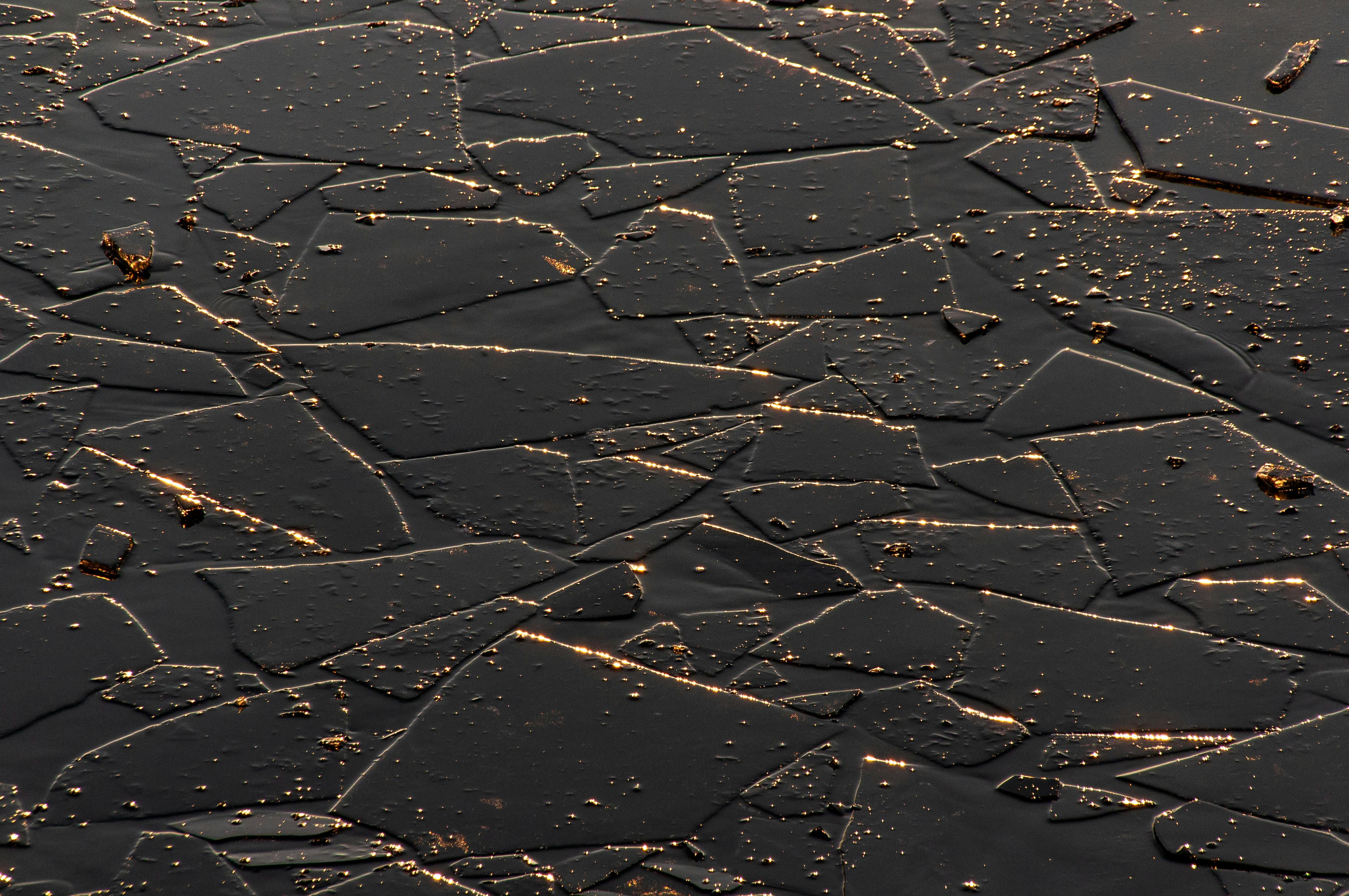 免费 破碎的冰块呈现出错综复杂的抽象图案，闪烁着金色的光芒，营造出独特的质感。 素材图片