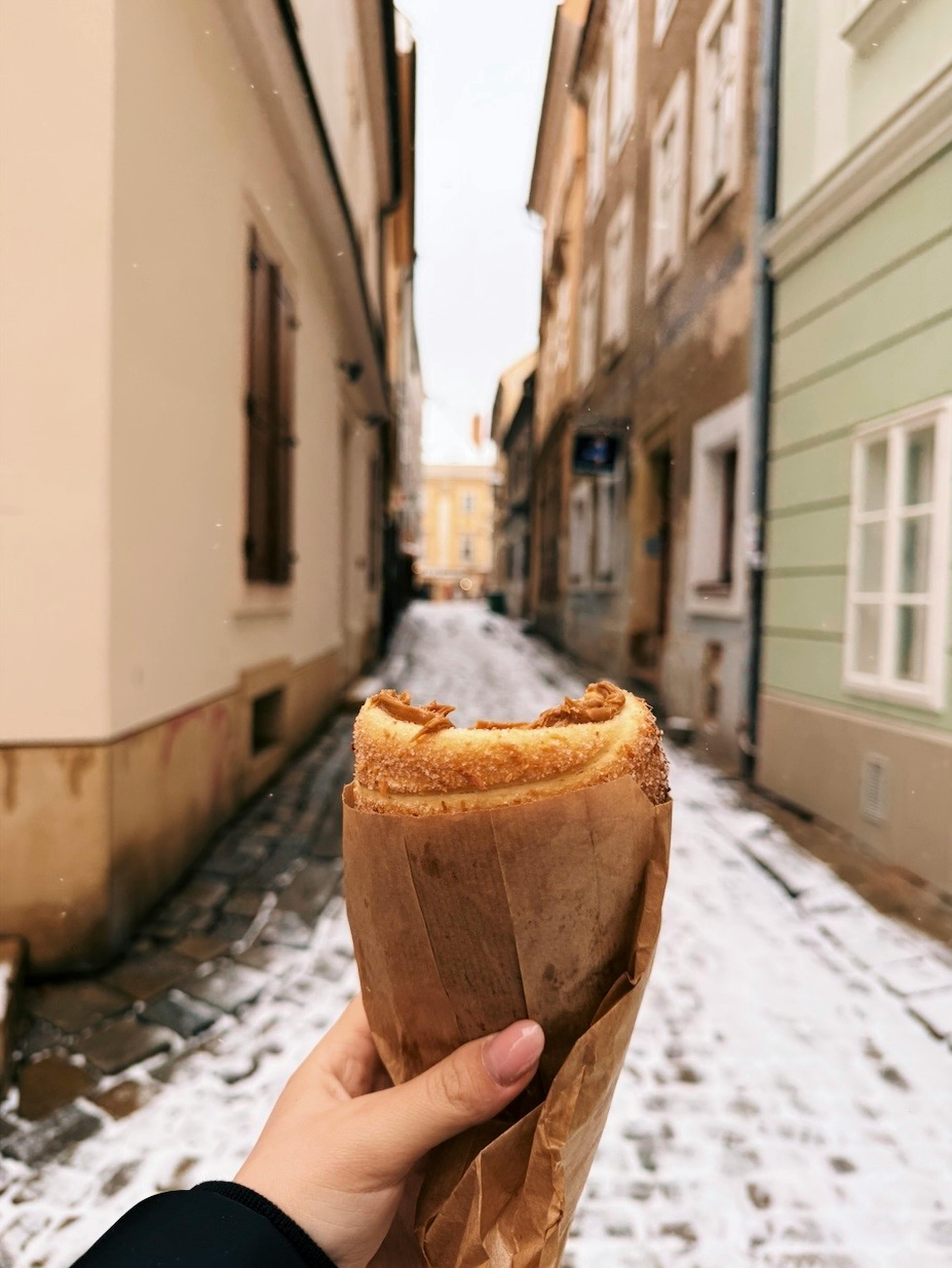 bezplatná Ruka držící trdelník na zasněžené ulici v Bratislavě na Slovensku. Základová fotografie