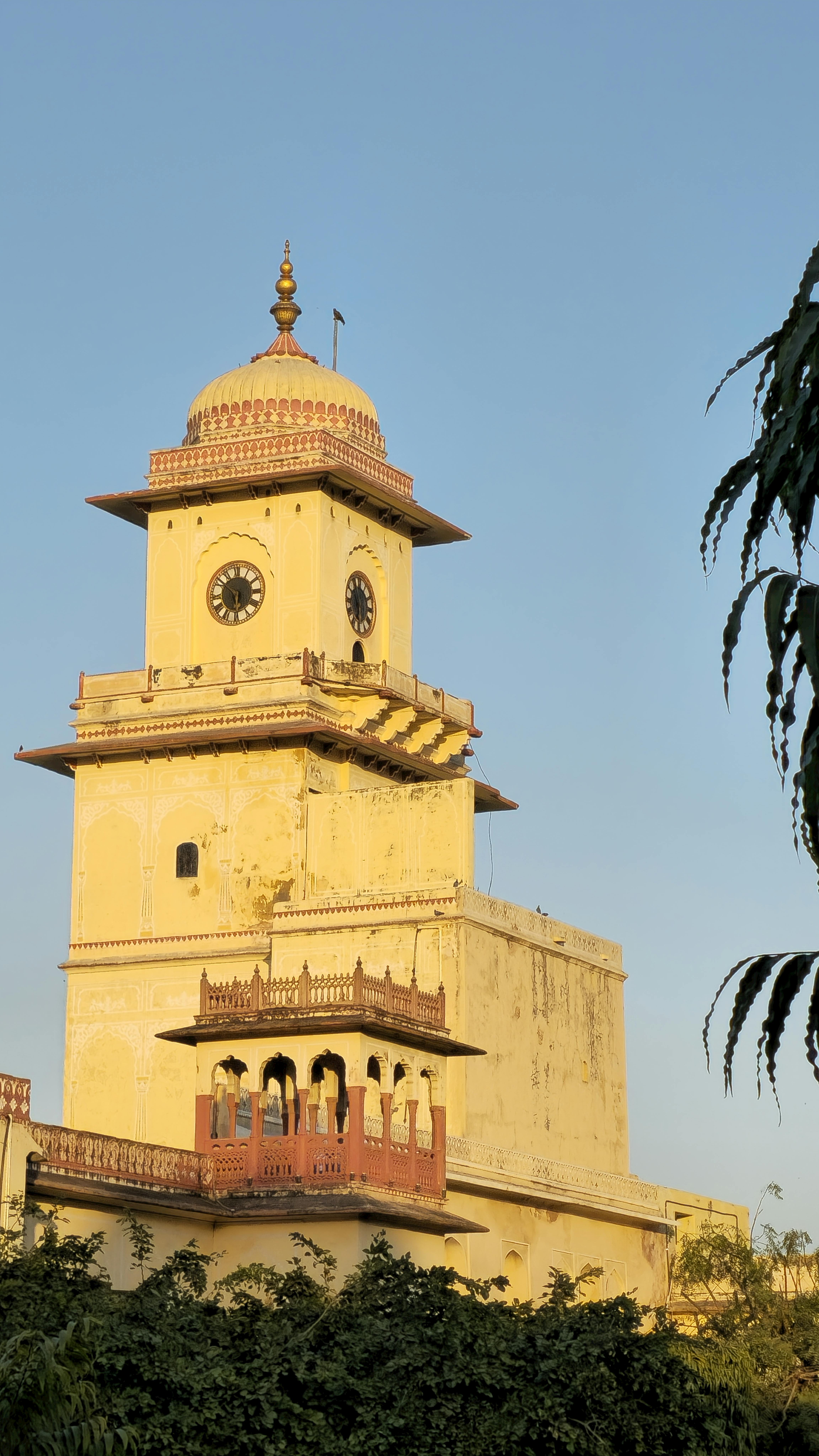 Ilmainen Kaunis historiallinen kellotorni Jaipurissa, Intiassa, kylpee kultaisessa auringonlaskun valossa. Kuvapankkikuva