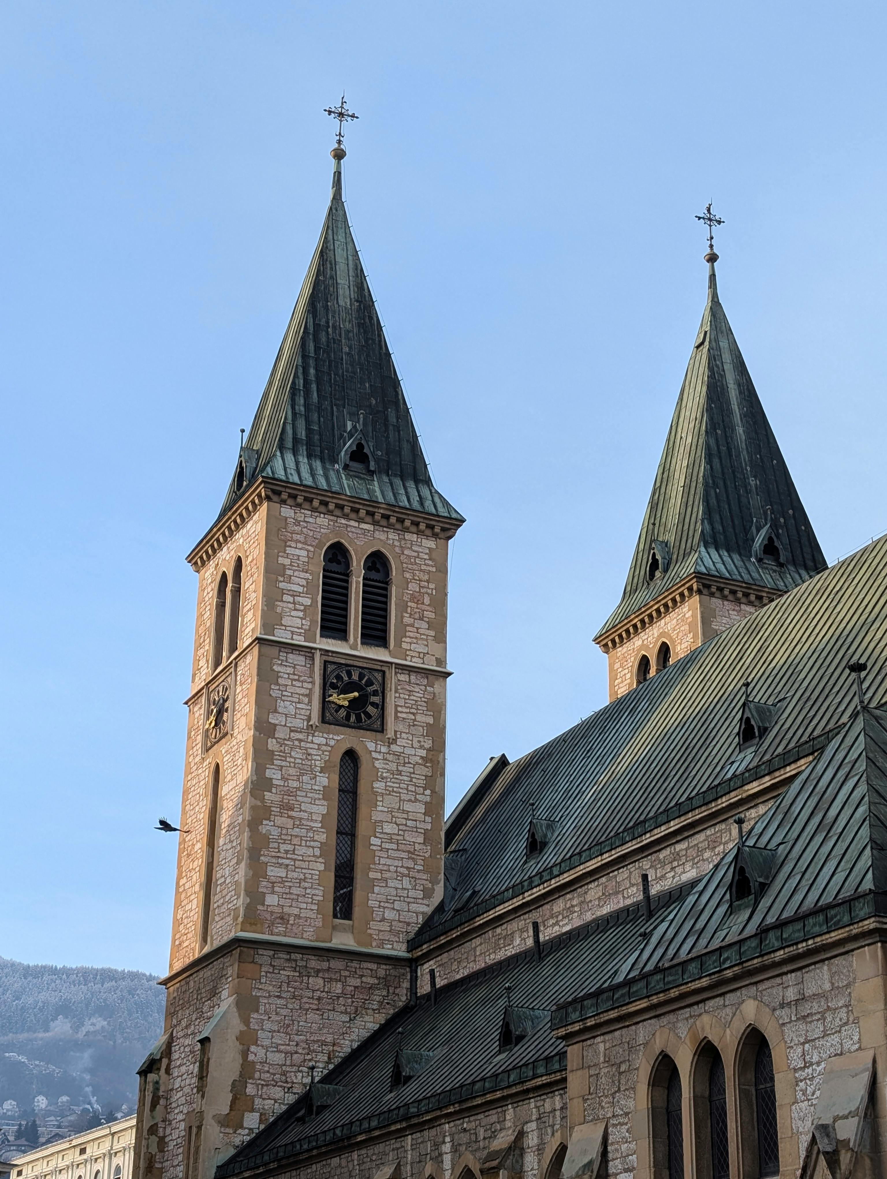 bezplatná Krásné kamenné kostelní věže se zelenými střechami na pozadí jasné modré oblohy. Základová fotografie