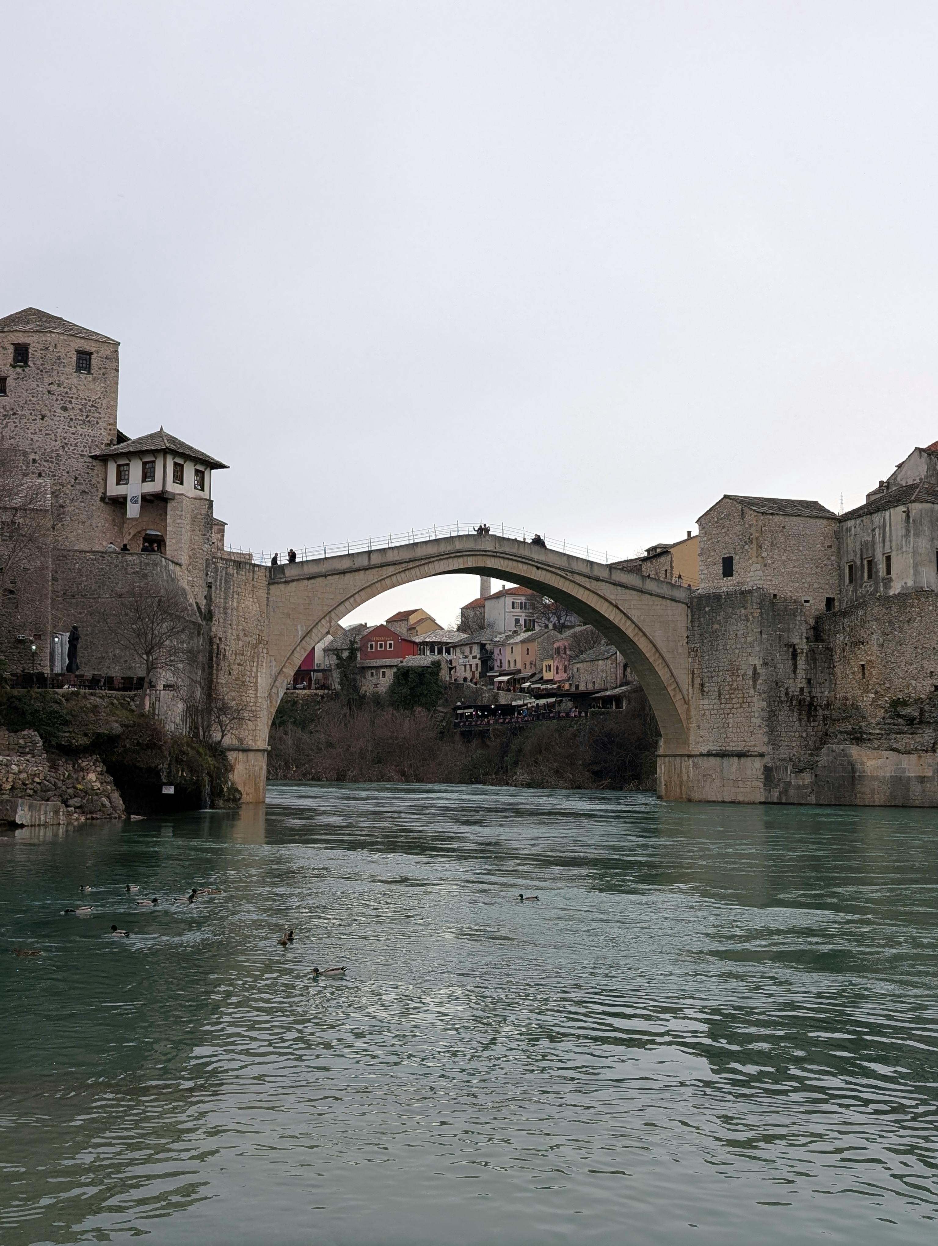 Ilmainen Historiallinen Stari Mostin silta Mostarissa ylittää Neretva-joen keskiaikaisen arkkitehtuurin ympäröimänä. Kuvapankkikuva