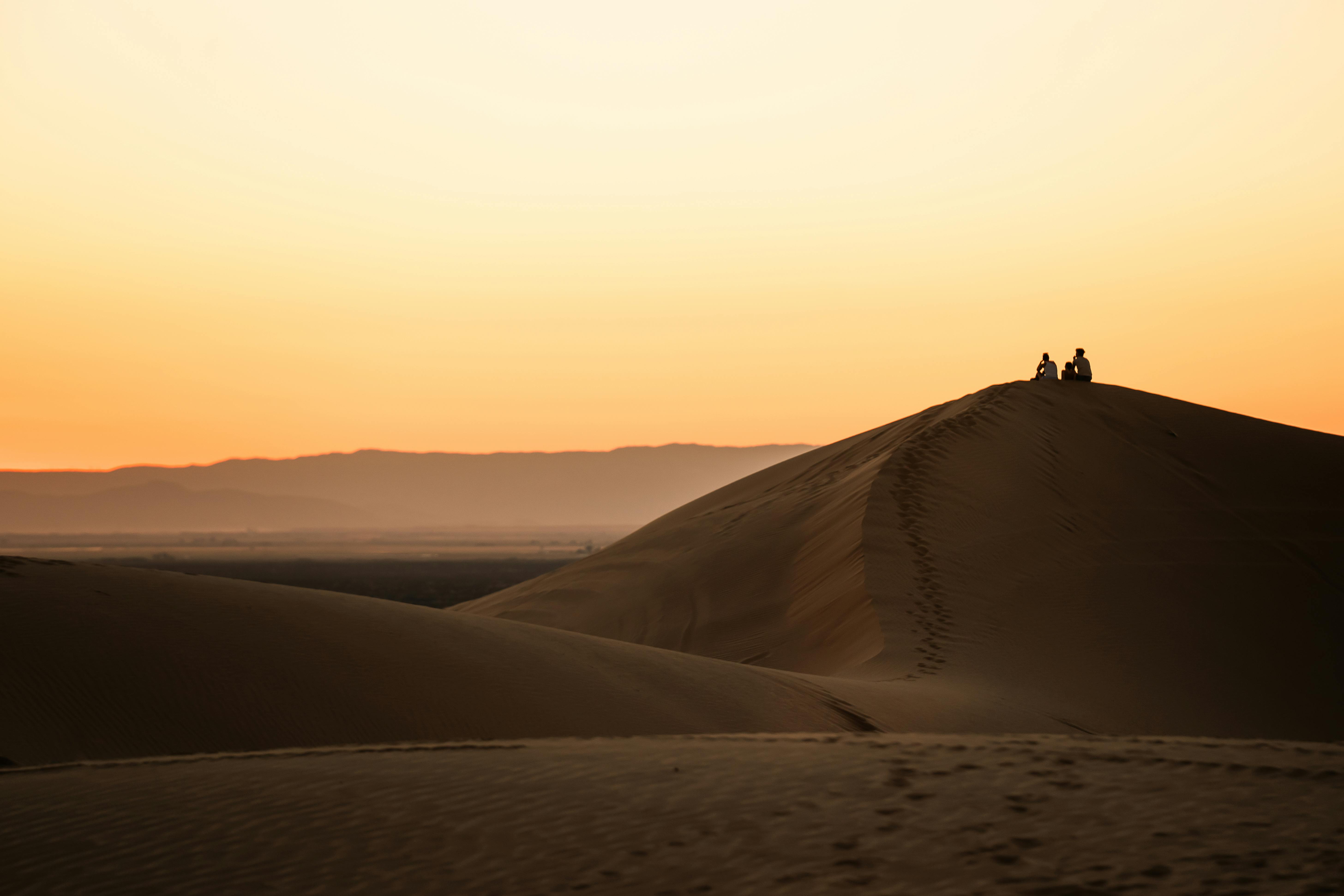 ฟรี พระอาทิตย์ตกดินอย่างสงบเหนือเนินทรายบรอว์ลีย์ พร้อมเงาของคนกำลังเพลิดเพลินกับทิวทัศน์ คลังภาพถ่าย