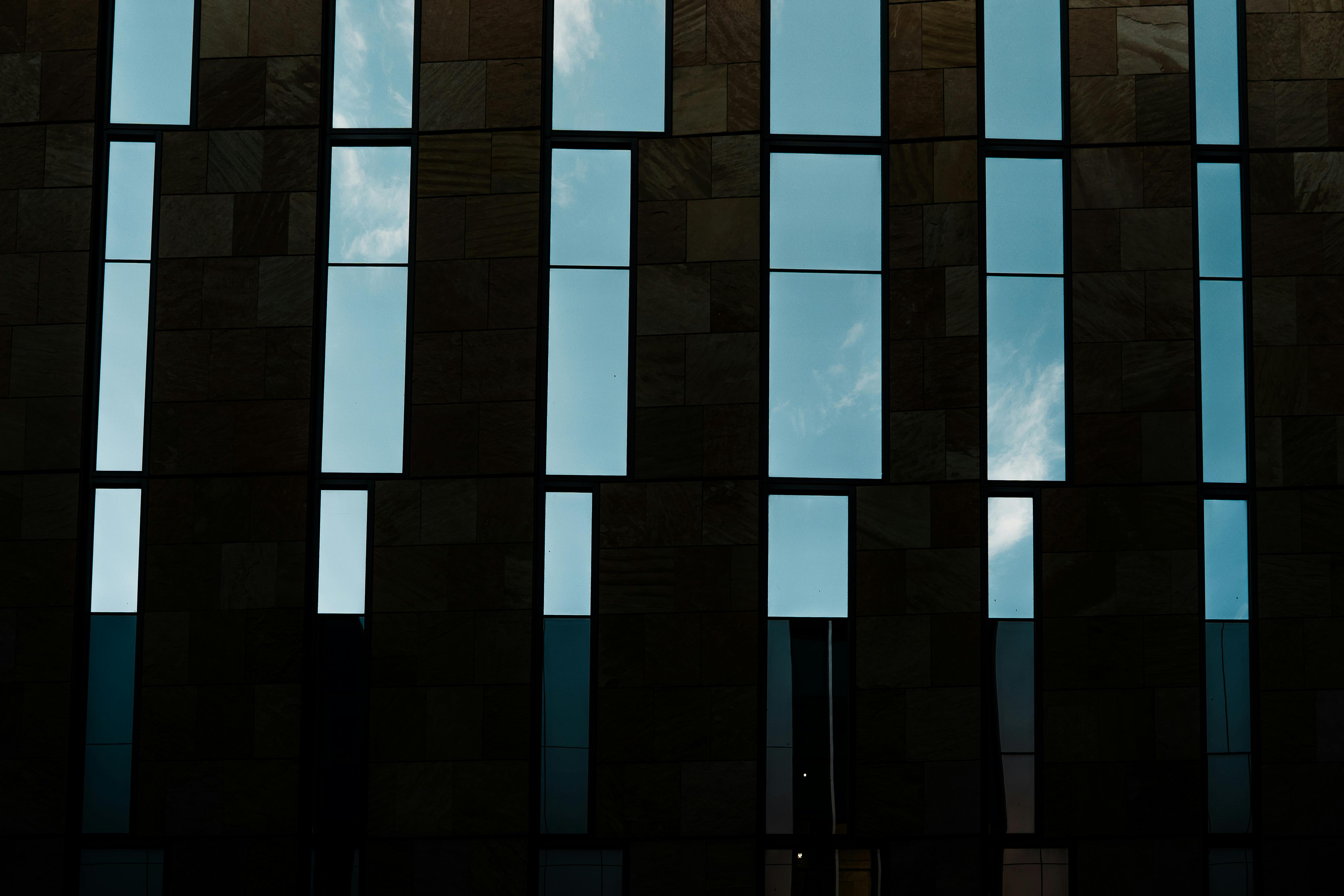 Kostenlos Geometrische Fenster an einer modernen Gebäudefassade spiegeln den klaren Himmel in Phoenix, Arizona, wider. Stock-Foto