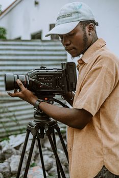 A young man with a professional camera on a tripod, focused on filming outdoors, in Sinzig.