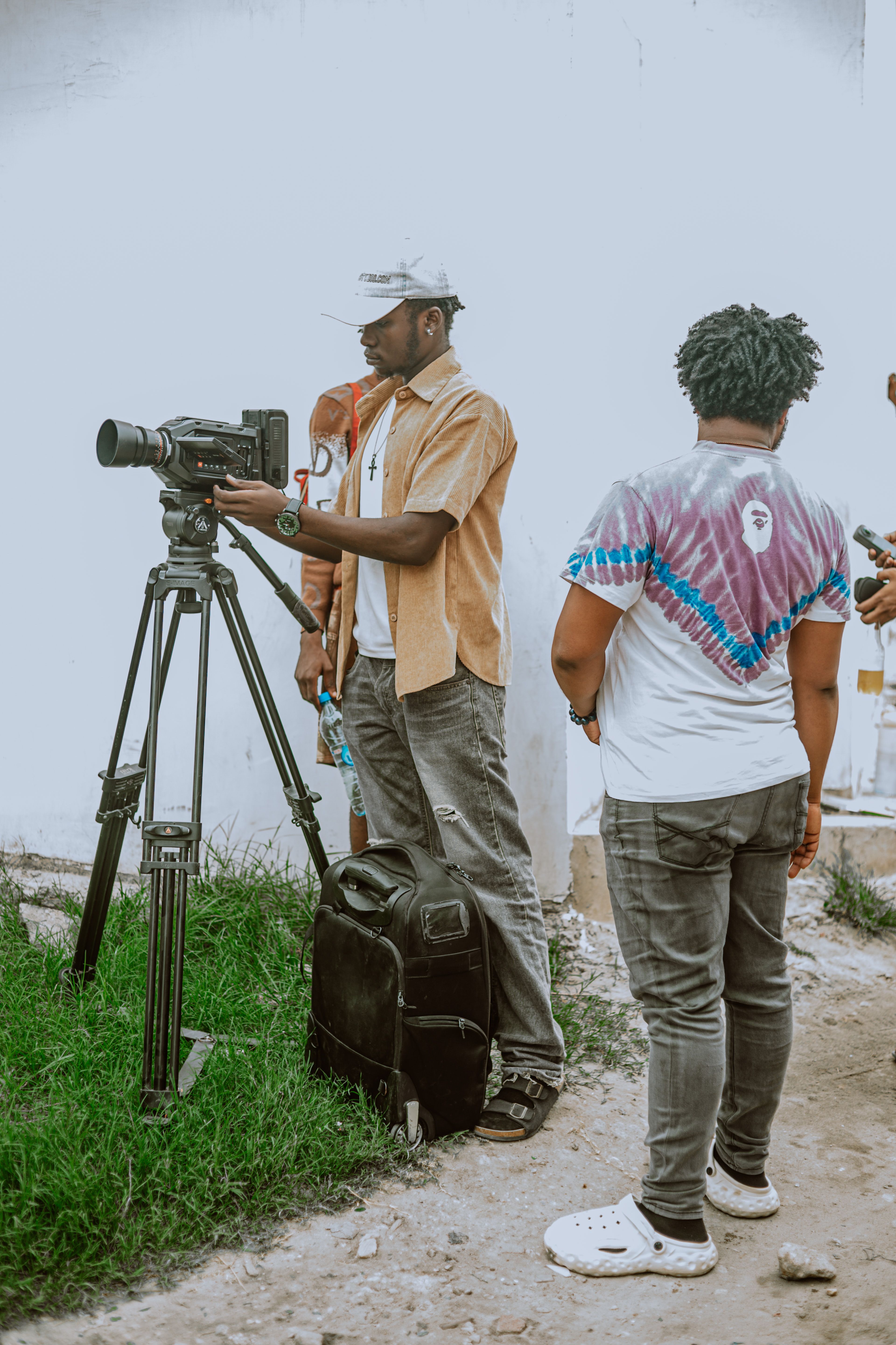 A diverse team setting up camera equipment outside for a film shoot.