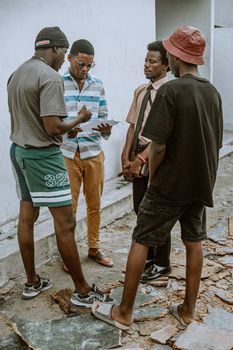 Four young adults engaged in a casual outdoor discussion on a sunny day.