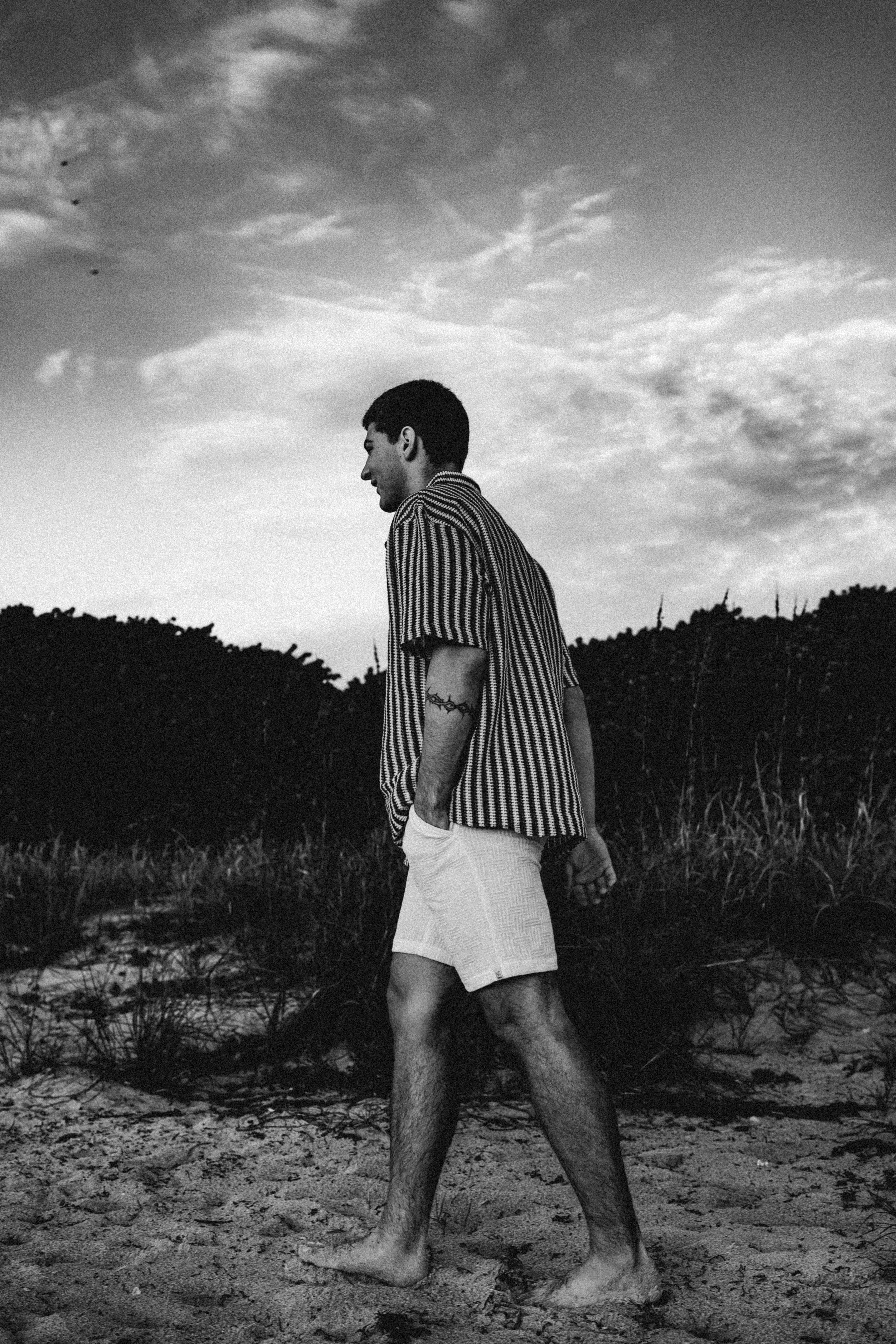 ฟรี ภาพถ่ายขาวดำของบุคคลที่เดินเท้าเปล่าบนชายหาด สวมเสื้อลายทาง คลังภาพถ่าย