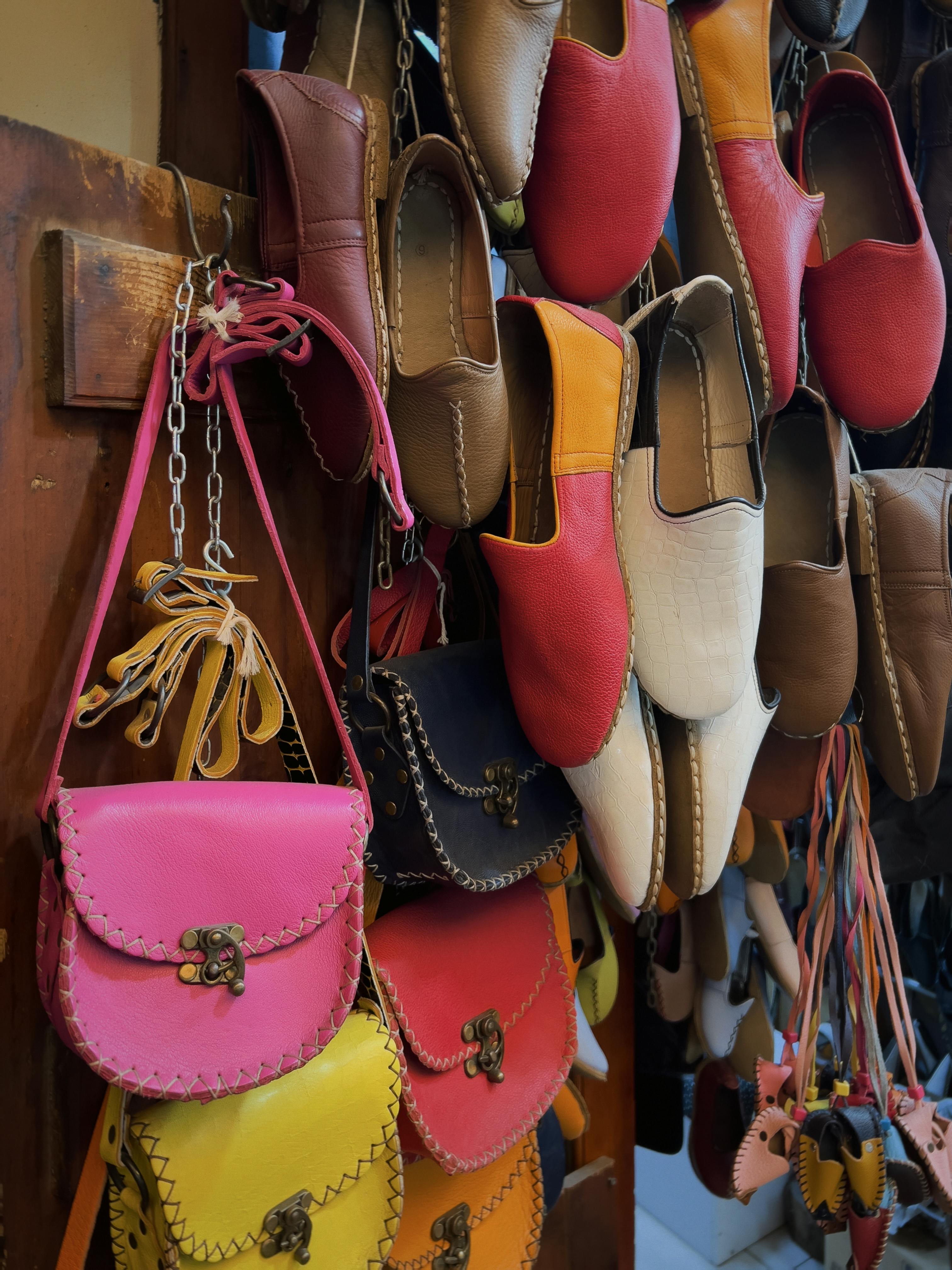 ฟรี การจัดแสดงรองเท้าและกระเป๋าหนังทำมือหลากหลายสีสันและดีไซน์อย่างสวยงาม คลังภาพถ่าย