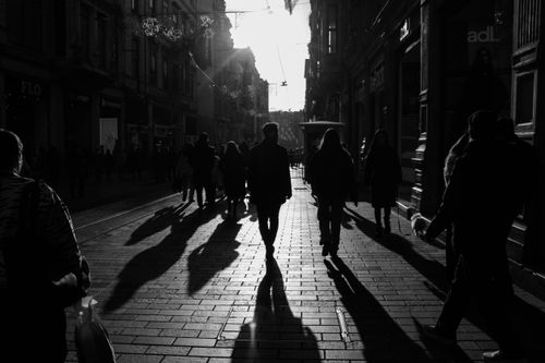 Free A dramatic black-and-white silhouette of people strolling down Istiklal Street in Istanbul at sunset. Stock Photo