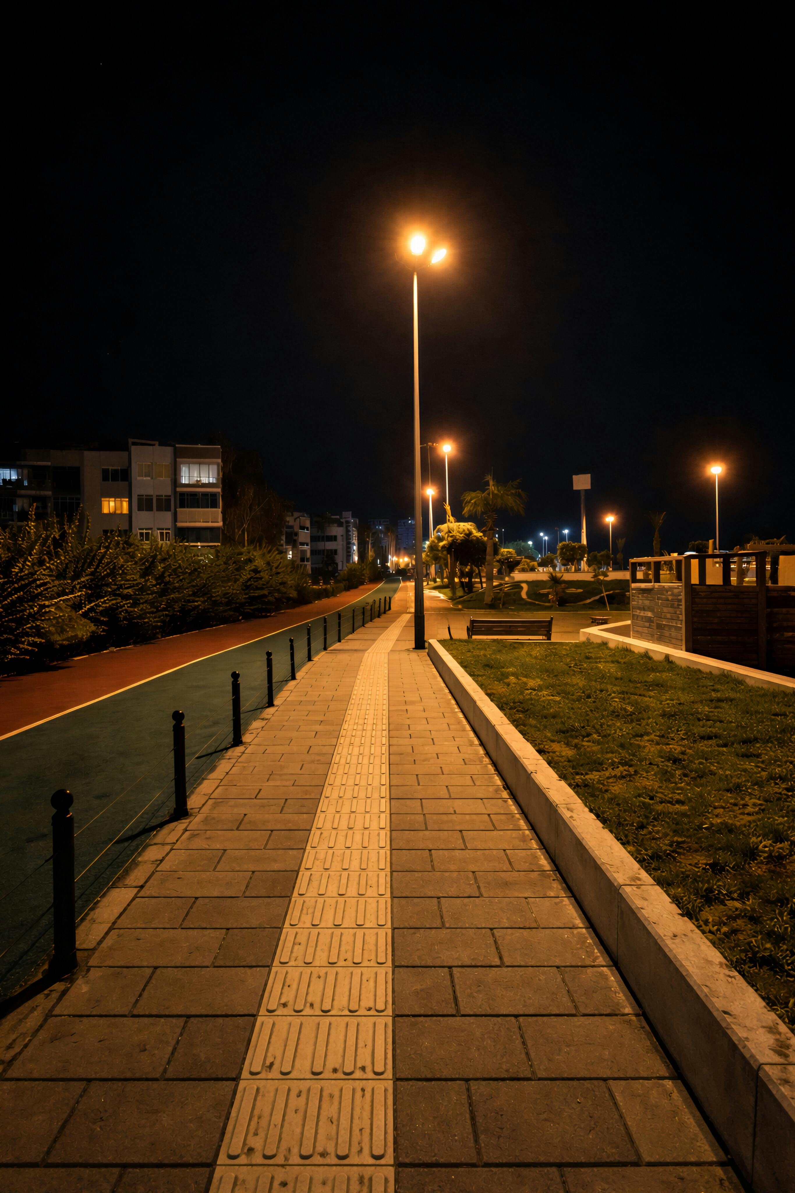 ฟรี ภาพบรรยากาศยามค่ำคืนอันเงียบสงบ แสดงให้เห็นทางเดินที่สว่างไสวในเมืองเมอร์ซิน ประเทศตุรกี คลังภาพถ่าย