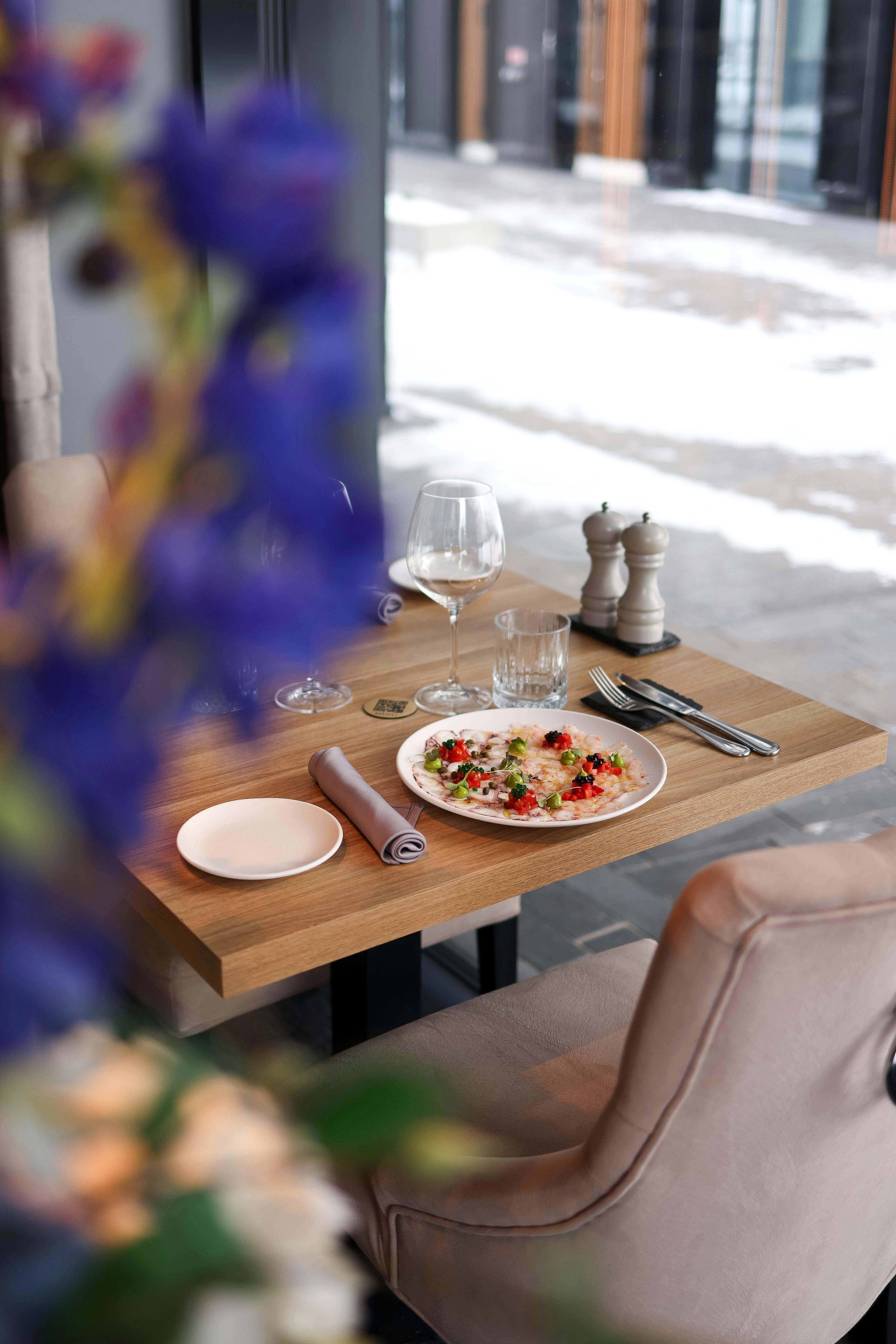 ฟรี โต๊ะอาหารในร้านอาหารบรรยากาศอบอุ่น พร้อมอาหารรสเลิศ ไวน์ชั้นดี และการตกแต่งที่หรูหรา มองเห็นวิวทิวทัศน์ของหิมะภายนอก คลังภาพถ่าย