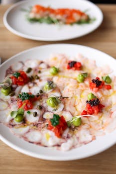 Close-up of a beautifully presented seafood carpaccio with vibrant garnishes.