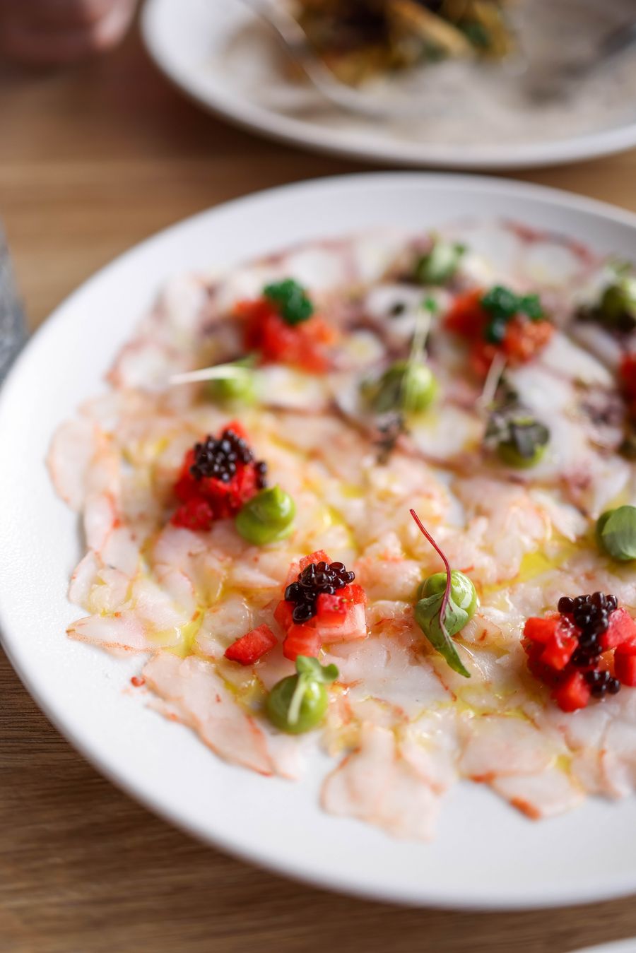 Tiradito clasico: laminas finas de pescado con aceite de oliva y alcaparras