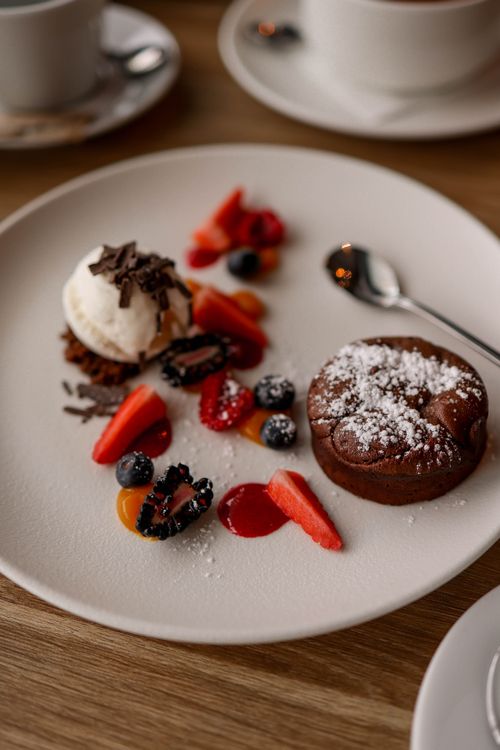 Free Luxurious dessert plate with chocolate fondant, ice cream, and fresh berries. Stock Photo