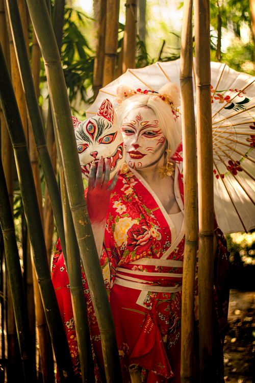 Free Artistic portrayal of a person in traditional Japanese attire amidst bamboo, highlighting cultural makeup and dress. Stock Photo