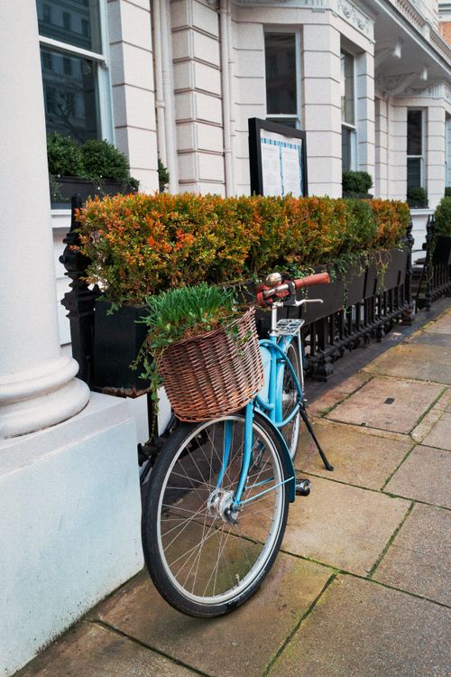 Free A picturesque scene of a bicycle with a wicker basket outside a vintage London townhouse. Stock Photo