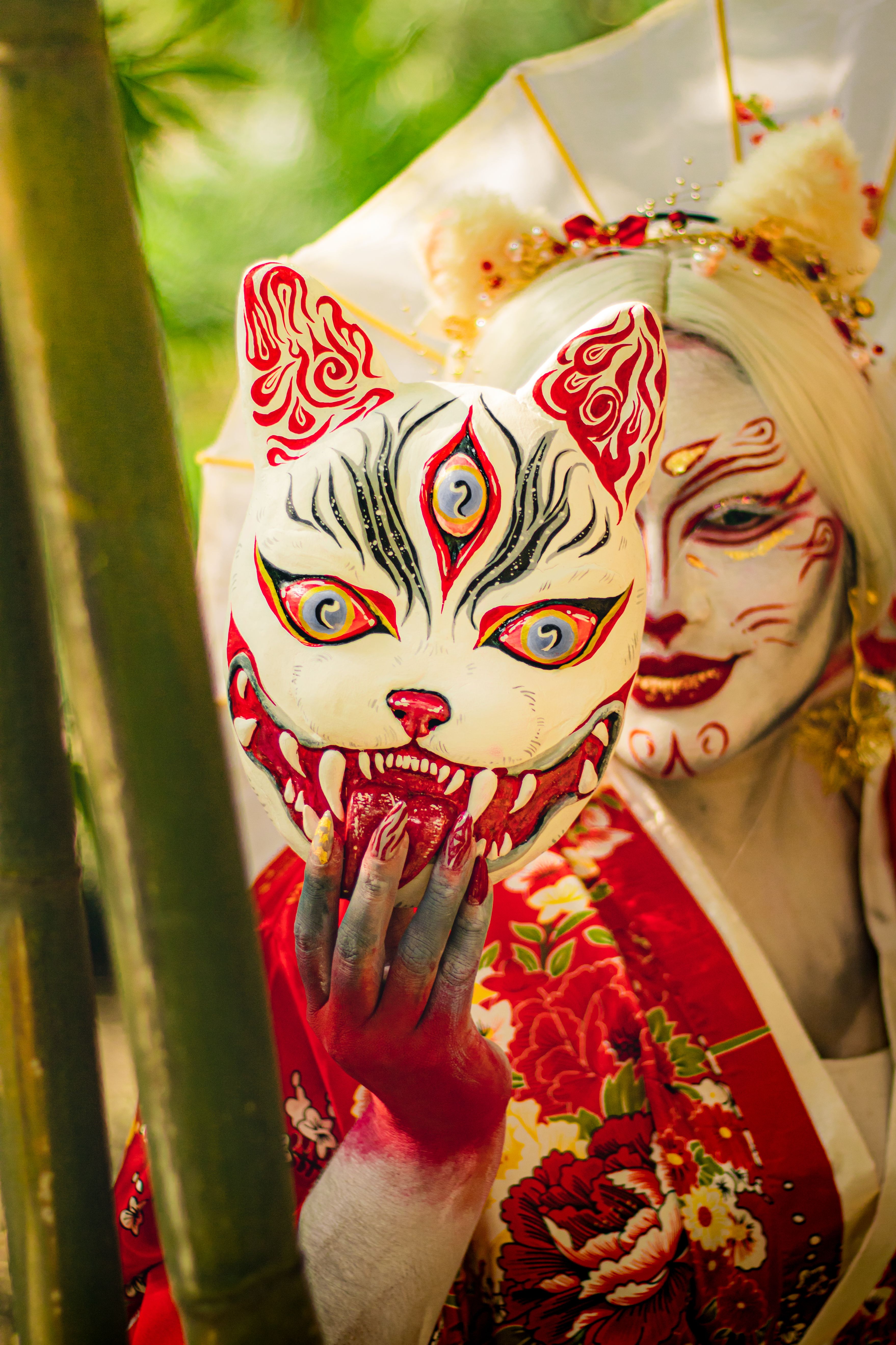 Colorful artistic portrait featuring a person in a kitsune mask and traditional red kimono.