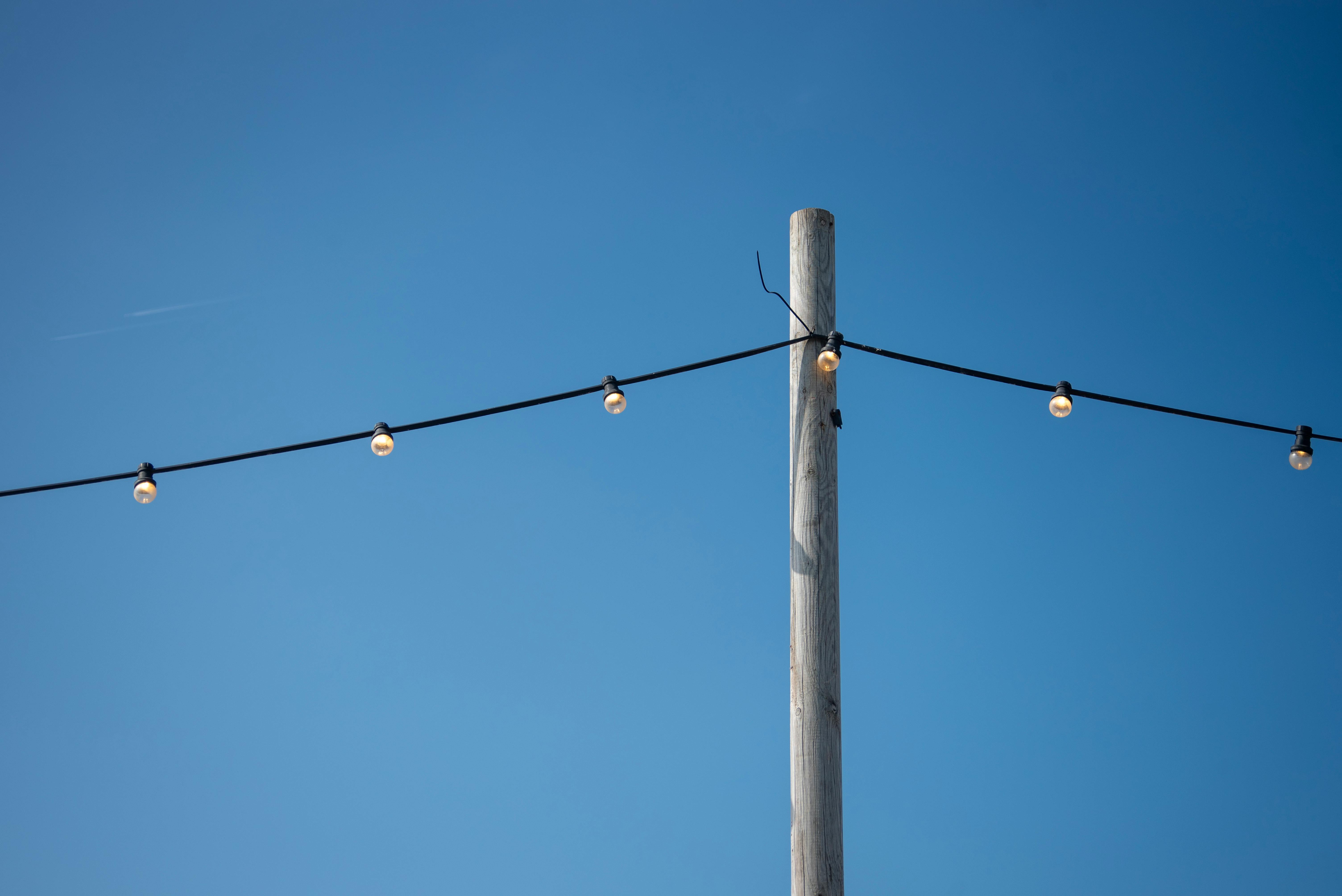 gratis Buitenverlichting aan een paal onder een helderblauwe hemel creëert een serene sfeer. Stockfoto