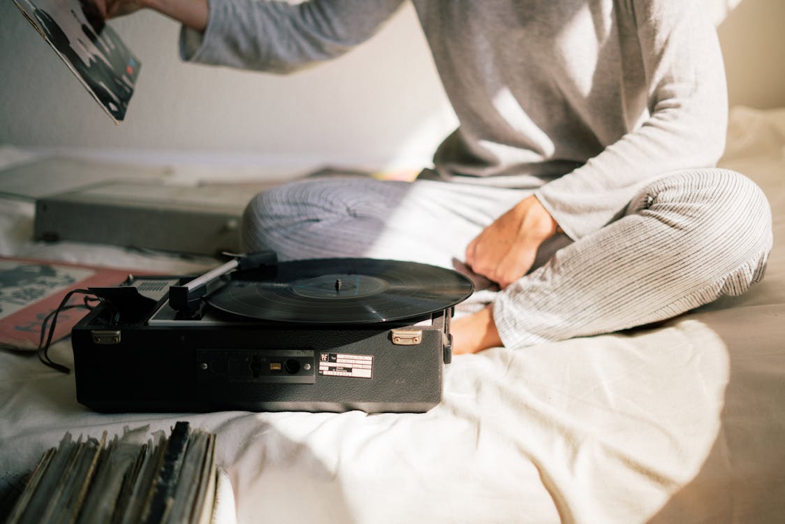 Free Person in Gray Sweater Holding Black Vinyl Record Player Stock Photo