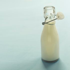 Glass bottle of milk on a plain backdrop — photo by Zakhar Vozhdaienko on Pexels