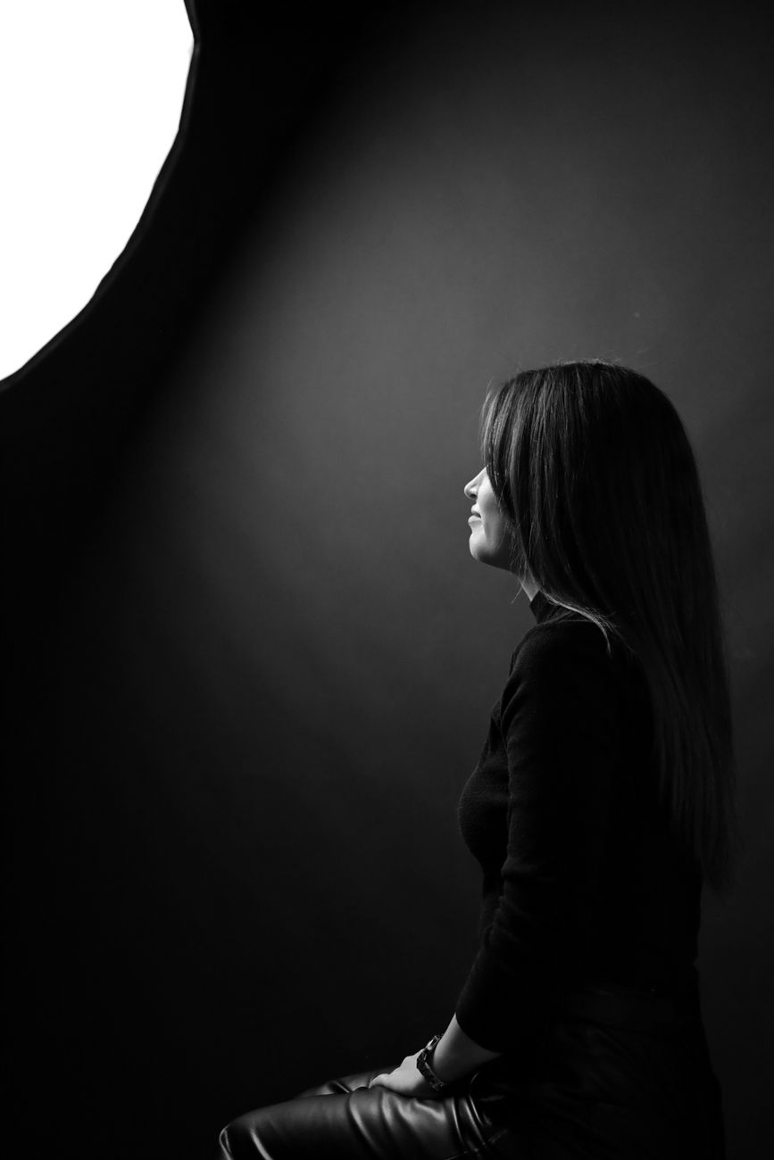 A dramatic profile of a woman in a studio with soft lighting for a classic portrait.. dramatic, profile, woman